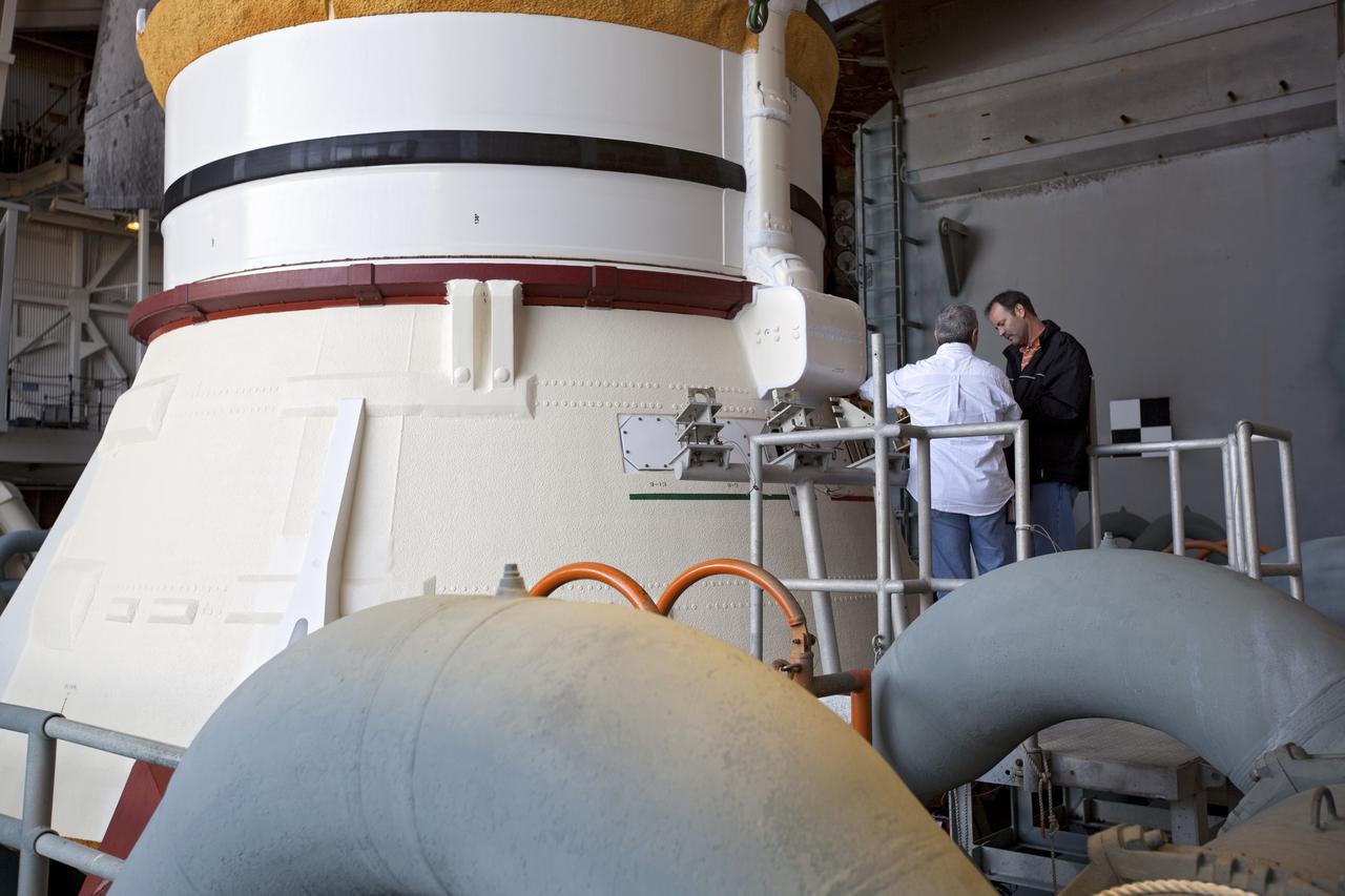 CAPE CANAVERAL, Fla. -- Preparations are under way in the Vehicle Assembly Building at NASA's Kennedy Space Center in Florida to examine space shuttle Discovery's external fuel tank. Shown here, is one of two solid rocket boosters, which are still attached to the external tank and shuttle. Technicians will begin to remove thermal sensors that will give engineers data about the changes the tank went through during the loading and draining of super-cold propellants during a tanking test on Dec. 17. Engineers also will examine 21-foot-long support beams, called stringers, on the outside of the tank's intertank region. Also on the agenda, is to re-apply foam to the outside of the tank. Discovery's next launch opportunity to the International Space Station on the STS-133 mission is no earlier than Feb. 3, 2011. For more information on STS-133, visit www.nasa.gov/mission_pages/shuttle/shuttlemissions/sts133/. Photo credit: NASA/Dimitri Gerondidakis