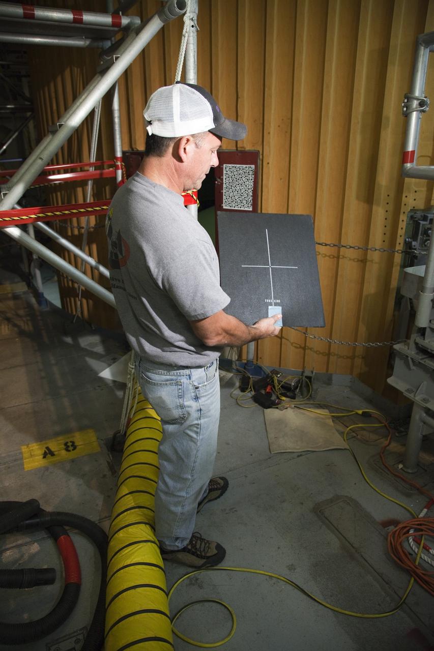 CAPE CANAVERAL, Fla. -- Inside the Vehicle Assembly Building at NASA's Kennedy Space Center in Florida, a technician holds the film used to project computed radiography scans of space shuttle Discovery's external fuel tank. The shuttle stack was moved from Launch Pad 39A to the Vehicle Assembly Building at NASA's Kennedy Space Center in Florida so technicians could examine 21-foot-long support beams, called stringers, on the outside of the tank's intertank and re-apply foam insulation. Discovery's next launch opportunity to the International Space Station on the STS-133 mission is no earlier than Feb. 3, 2011. For more information on STS-133, visit www.nasa.gov/mission_pages/shuttle/shuttlemissions/sts133/. Photo credit: NASA/Frankie Martin