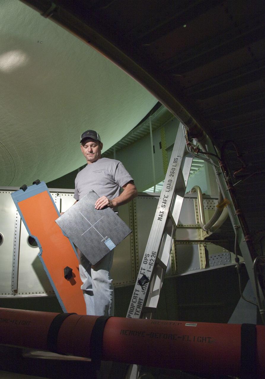 CAPE CANAVERAL, Fla. -- Inside the intertank of space shuttle Discovery's external fuel tank, a technician holds the film used to project computed radiography scans. The shuttle stack, consisting of the shuttle, external tank and solid rocket boosters, was moved from Launch Pad 39A to the Vehicle Assembly Building at NASA's Kennedy Space Center in Florida so technicians could examine 21-foot-long support beams, called stringers, on the outside of the tank's intertank and re-apply foam insulation. Discovery's next launch opportunity to the International Space Station on the STS-133 mission is no earlier than Feb. 3, 2011. For more information on STS-133, visit www.nasa.gov/mission_pages/shuttle/shuttlemissions/sts133/. Photo credit: NASA/Frankie Martin