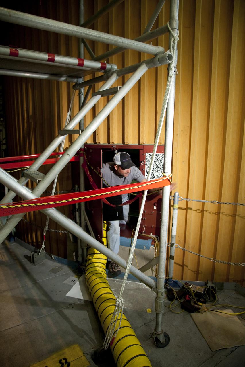 CAPE CANAVERAL, Fla. -- A technician exits the intertank of space shuttle Discovery's external fuel tank holding the film used to project computed radiography scans. The shuttle stack was moved from Launch Pad 39A to the Vehicle Assembly Building at NASA's Kennedy Space Center in Florida so technicians could examine 21-foot-long support beams, called stringers, on the outside of the tank's intertank and re-apply foam insulation. Discovery's next launch opportunity to the International Space Station on the STS-133 mission is no earlier than Feb. 3, 2011. For more information on STS-133, visit www.nasa.gov/mission_pages/shuttle/shuttlemissions/sts133/. Photo credit: NASA/Frankie Martin