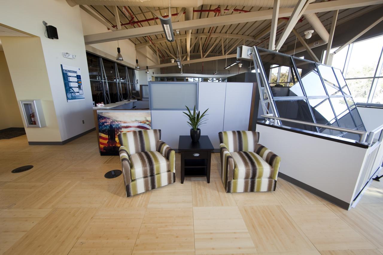 CAPE CANAVERAL, Fla. -- Finishing touches adorn the second-floor lobby of the Propellants North Administrative and Maintenance Facility at NASA's Kennedy Space Center in Florida. At right, are recycled firing room windows that are set at the same angle and orientation as they were in Kennedy's Launch Control Center, looking out toward Launch Pads 39A and B. The environmentally friendly facility is slated to be NASA's second Platinum-rated by the U.S. Green Building Council's (USGBC) Leadership in Environmental and Energy Design (LEED) certification system. It will be the space agency's first net-zero facility, which means it will produce enough energy onsite from renewable sources to offset what it requires to operate. The facility consists of a two-story administrative building to house managers, mechanics and technicians who fuel spacecraft at Kennedy, and a single-story shop to store cryogenic fuel transfer equipment. Photo credit: NASA/Frankie Martin