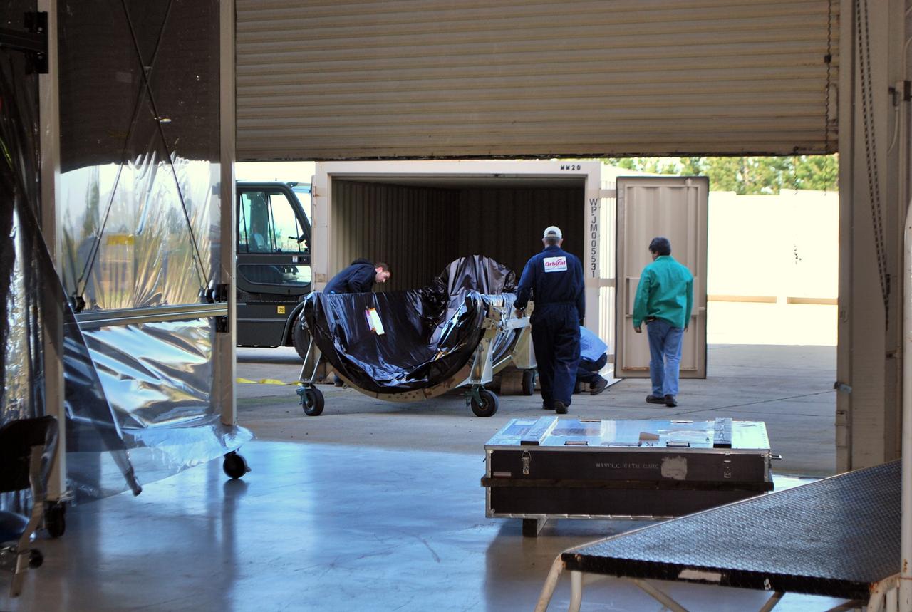 VANDENBERG AIR FORCE BASE, Calif. -- Workers move one half of the fairing, wrapped in  plastic protective covering, into a cargo container for transport from  the Orbital Sciences Corp. Building 1555 at Vandenberg Air Force Base in California to the Astrotech Payload Processing Facility.    Once both halves of the fairing are delivered to Astrotech they will be installed around NASA's Glory satellite to protect it from the weather at the launch pad as well as from the atmosphere during flight. A four-stage Taurus XL rocket will carry Glory into low Earth orbit. Once Glory reaches orbit, it will collect data on the properties of aerosols and black carbon. It also will help scientists understand how the sun's irradiance affects Earth's climate. Launch is scheduled for 2:09 a.m. PST Feb. 23 from Vandenberg's Space Launch Complex 576-E. For information, visit www.nasa.gov/glory. Photo credit: NASA/Randy Beaudoin, VAFB