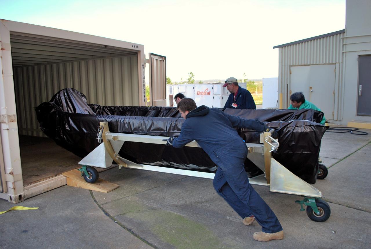 VANDENBERG AIR FORCE BASE, Calif. -- Workers move one half of the fairing, wrapped in  plastic protective covering, into a cargo container for transport from  the Orbital Sciences Corp. Building 1555 at Vandenberg Air Force Base in California to the Astrotech Payload Processing Facility.    Once both halves of the fairing are delivered to Astrotech they will be installed around NASA's Glory satellite to protect it from the weather at the launch pad as well as from the atmosphere during flight. A four-stage Taurus XL rocket will carry Glory into low Earth orbit. Once Glory reaches orbit, it will collect data on the properties of aerosols and black carbon. It also will help scientists understand how the sun's irradiance affects Earth's climate. Launch is scheduled for 2:09 a.m. PST Feb. 23 from Vandenberg's Space Launch Complex 576-E. For information, visit www.nasa.gov/glory. Photo credit: NASA/Randy Beaudoin, VAFB