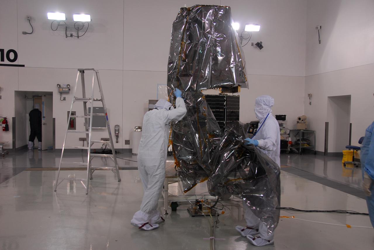 VANDENBERG AIR FORCE BASE, Calif. -- Inside the Astrotech payload processing facility at Vandenberg Air Force Base in California, technicians begin to remove the protective covering surrounding NASA's Glory spacecraft. Next, the spacecraft will be encapsulated in its protective payload fairing before it is transported to Space Launch Complex 576-E and joined with the Taurus XL rocket's third stage. Once Glory reaches orbit, it will collect data on the properties of aerosols and black carbon. It also will help scientists understand how the sun's irradiance affects Earth's climate. Launch is scheduled for 5:09 a.m. EST Feb. 23. For information, visit www.nasa.gov/glory. Photo credit: NASA/Ed Henry, VAFB