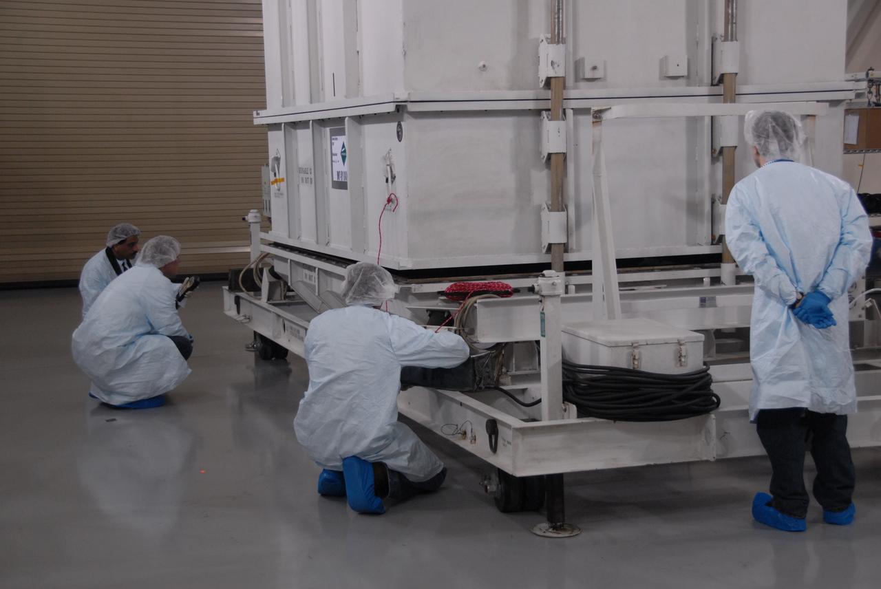 VANDENBERG AIR FORCE BASE, Calif. -- Inside the Astrotech processing facility at Vandenberg Air Force Base in California, technicians prepare to remove the shipping container surrounding NASA's Glory spacecraft. Next, technicians will take off Glory's protective covering before it is encapsulated in a protective payload fairing for flight. In early February, Glory is scheduled to be transported Space Launch Complex 576-E where it will be joined with the Taurus XL rocket, which is manufactured by Orbital Sciences Corp.        Once Glory reaches orbit, it will collect data on the properties of aerosols and black carbon. It also will help scientists understand how the sun's irradiance affects Earth's climate. Launch is scheduled for 5:09 a.m. EST Feb. 23. For information, visit www.nasa.gov/glory. Photo credit: NASA/Ed Henry, VAFB
