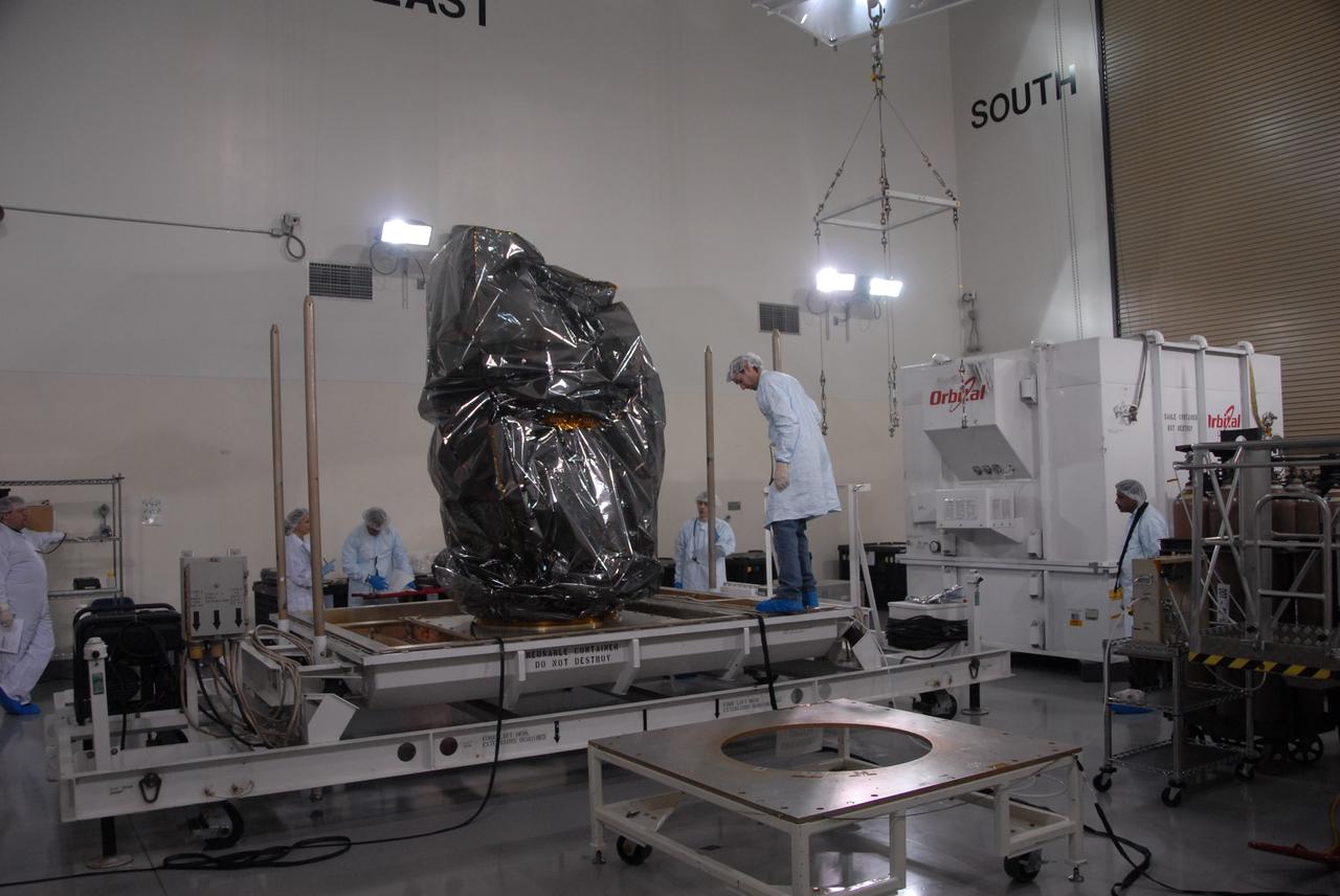 VANDENBERG AIR FORCE BASE, Calif. -- Inside the Astrotech processing facility at Vandenberg Air Force Base in California, technicians prepare to transfer NASA's Glory spacecraft to a processing dolly.  Next, technicians will take off Glory's protective covering before it is encapsulated in a protective payload fairing for flight. In early February, Glory is scheduled to be transported Space Launch Complex 576-E where it will be joined with the Taurus XL rocket, which is manufactured by Orbital Sciences Corp.          Once Glory reaches orbit, it will collect data on the properties of aerosols and black carbon. It also will help scientists understand how the sun's irradiance affects Earth's climate. Launch is scheduled for 5:09 a.m. EST Feb. 23. For information, visit www.nasa.gov/glory. Photo credit: NASA/Ed Henry, VAFB