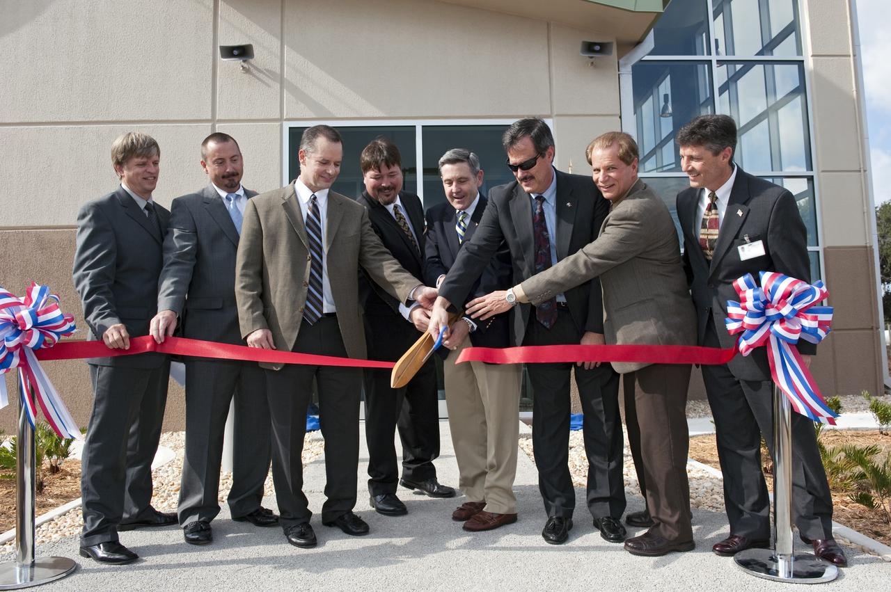 CAPE CANAVERAL, Fla. -- A traditional ribbon-cutting ceremony takes place outside the Propellants North Administration and Maintenance Facility at NASA's Kennedy Space Center in Florida. From left, are Thomas Wilczek, contracting officer technical representative/project manager for NASA Construction of Facilities; Bradley O’Toole, NASA contracting officer; James Wright, deputy assistant administrator for the Office of Strategic Infrastructure at NASA Headquarters; Frank Kline, NASA Construction of Facility project manager; Bob Cabana, Kennedy's center director; Mike Benik, director of Kennedy's Center Operations; Ward Davis, president of HW Davis Construction Inc.; and Rick Ferreira, chief operating officer of Jones Edmunds and Associates Inc. Propellants North consists of two buildings, one to store cryogenic fuel transfer equipment and one to house personnel who support fueling spacecraft. The recently rebuilt buildings will be NASA's first carbon neutral facility, which means it will produce enough energy on site from renewable sources to offset what it requires to operate. The facility also will reach for the U.S. Green Building Council's Leadership in Environmental and Energy Design (LEED) Platinum status, which is the highest LEED rating. Photo credit: NASA/Kim Shiflett