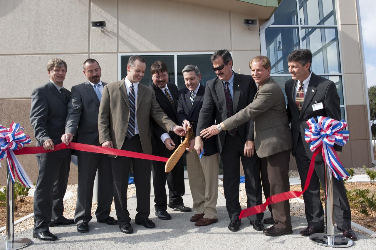 CAPE CANAVERAL, Fla. -- A traditional ribbon-cutting ceremony takes place outside the Propellants North Administration and Maintenance Facility at NASA's Kennedy Space Center in Florida. From left, are Thomas Wilczek, contracting officer technical representative/project manager for NASA Construction of Facilities; Bradley O’Toole, NASA contracting officer; James Wright, deputy assistant administrator for the Office of Strategic Infrastructure at NASA Headquarters; Frank Kline, NASA Construction of Facility project manager; Bob Cabana, Kennedy's center director; Mike Benik, director of Kennedy's Center Operations; Ward Davis, president of HW Davis Construction Inc.; and Rick Ferreira, chief operating officer of Jones Edmunds and Associates Inc. Propellants North consists of two buildings, one to store cryogenic fuel transfer equipment and one to house personnel who support fueling spacecraft. The recently rebuilt buildings will be NASA's first carbon neutral facility, which means it will produce enough energy on site from renewable sources to offset what it requires to operate. The facility also will reach for the U.S. Green Building Council's Leadership in Environmental and Energy Design (LEED) Platinum status, which is the highest LEED rating. Photo credit: NASA/Kim Shiflett