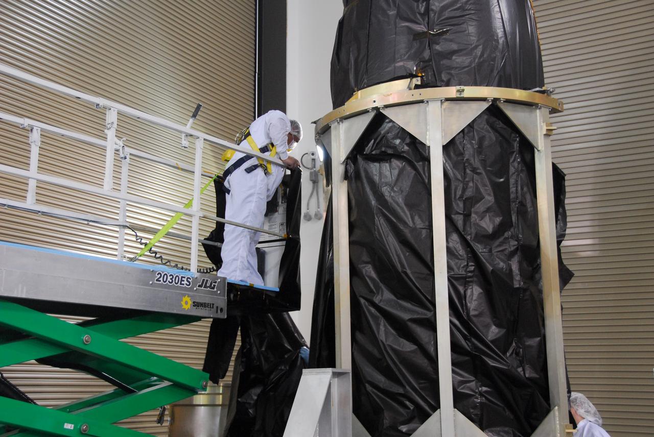 VANDENBERG AIR FORCE BASE, Calif. -- A technician prepare to remove the covering of the payload fairing for the Glory mission. He is working inside the Astrotech payload processing facility at Vandenberg Air Force Base in California. The payload fairing will protect the Glory spacecraft from aerodynamic pressures and heating during the first part of its climb into orbit. Once Glory reaches orbit, it will collect data on the properties of aerosols and black carbon. It also will help scientists understand how the sun's irradiance affects Earth's climate. Launch is scheduled for 5:09 a.m. EST Feb. 23. For information, visit www.nasa.gov/glory. Photo credit: NASA/Ed Henry, VAFB