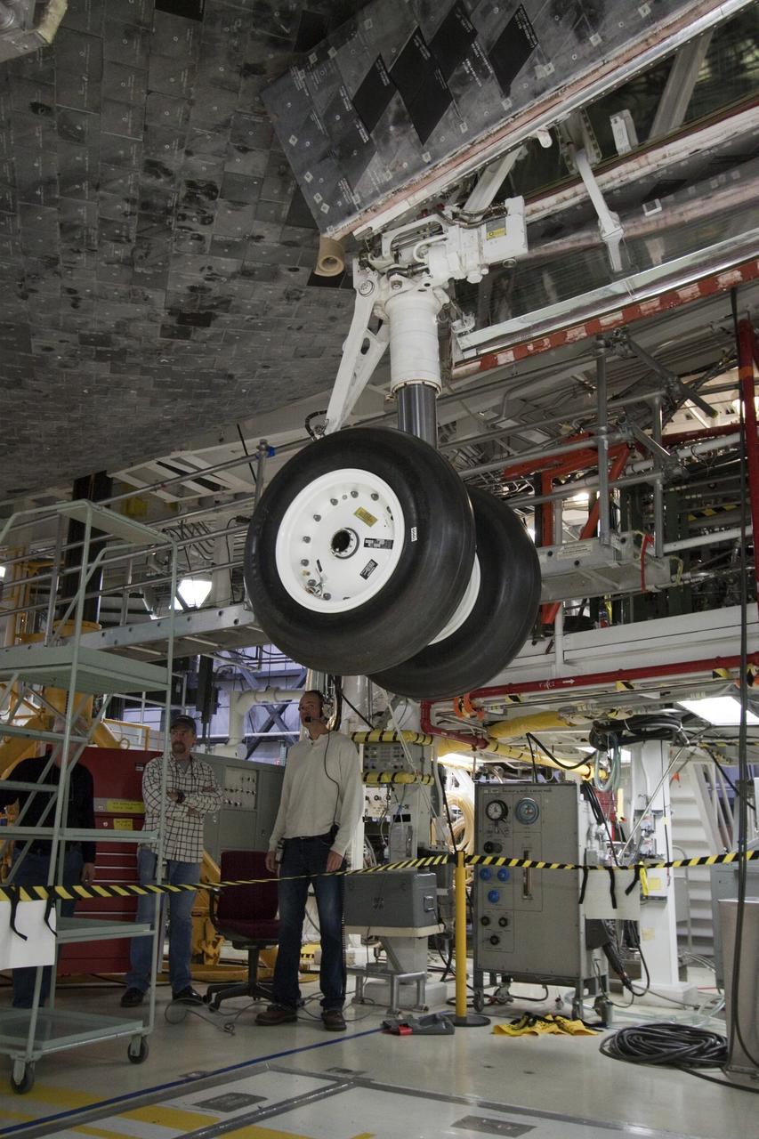 CAPE CANAVERAL, Fla. -- Space shuttle Atlantis  goes through a routine landing gear test in Orbiter Processing Facility-1 at NASA's Kennedy Space Center in Florida. Technicians are checking to make sure the shuttle's wheels, brakes, elevons and body flap function properly. Seen here, the nose landing gear is deployed. During a shuttle landing, the nose gear comes down after the main gear and helps the shuttle coast to a stop.            Atlantis is being prepared for the STS-135 mission, which will deliver the Raffaello multi-purpose logistics module packed with supplies, logistics and spare parts to the International Space Station. STS-135 is targeted to launch June 28, and will be the last spaceflight for the Space Shuttle Program. Photo credit: NASA/Jack Pfaller