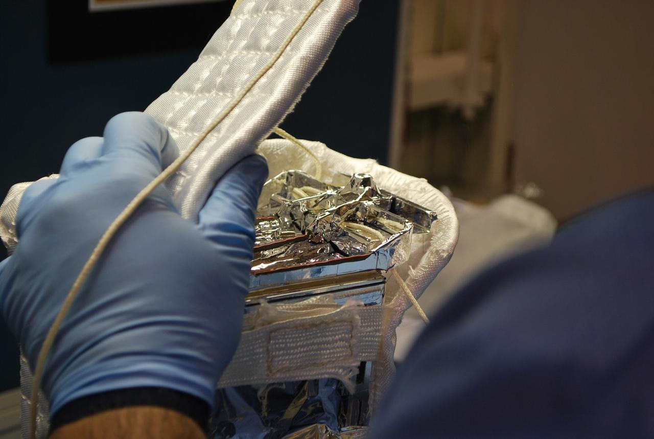 VANDENBERG AIR FORCE BASE, Calif. -- At Vandenberg Air Force Base in California, a technician completes the wrapping of the Poly Picosatellite Orbital Deployer, or P-POD, assembly in a protective insulation blanket. The P-POD will hold three CubeSats or tiny satellites, designed and created by university and college students that will be carried on the Taurus rocket along with the Glory spacecraft. The Orbital Sciences Corp. Taurus XL rocket will carry NASA's Glory spacecraft into low Earth orbit. Once Glory reaches orbit, it will collect data on the properties of aerosols and black carbon. It also will help scientists understand how the sun's irradiance affects Earth's climate. Launch is scheduled for 5:09 a.m. EST Feb. 23. For information, visit www.nasa.gov/glory. Photo credit: NASA/Randy Beaudoin, VAFB