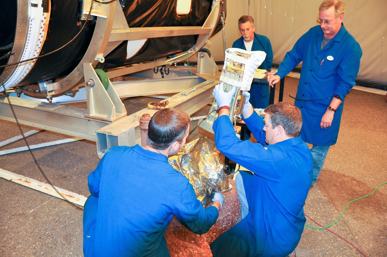 VANDENBERG AIR FORCE BASE, Calif. -- At Space Launch Complex 576-E at Vandenberg Air Force Base in California, technicians carefully lift the Poly Picosatellite Orbital Deployer, or P-POD, assembly out of its wrappings prior to installation to the aft end of the Taurus rocket's third stage. The P-POD holds three CubeSats or tiny satellites, designed and created by university and college students that will be carried on the Taurus rocket along with the Glory spacecraft.         The Orbital Sciences Corp. Taurus XL rocket will carry Glory into low Earth orbit. Once Glory reaches orbit, it will collect data on the properties of aerosols and black carbon. It also will help scientists understand how the sun's irradiance affects Earth's climate. Launch is scheduled for 5:09 a.m. EST Feb. 23. For information, visit www.nasa.gov/glory. Photo credit: NASA/Randy Beaudoin, VAFB