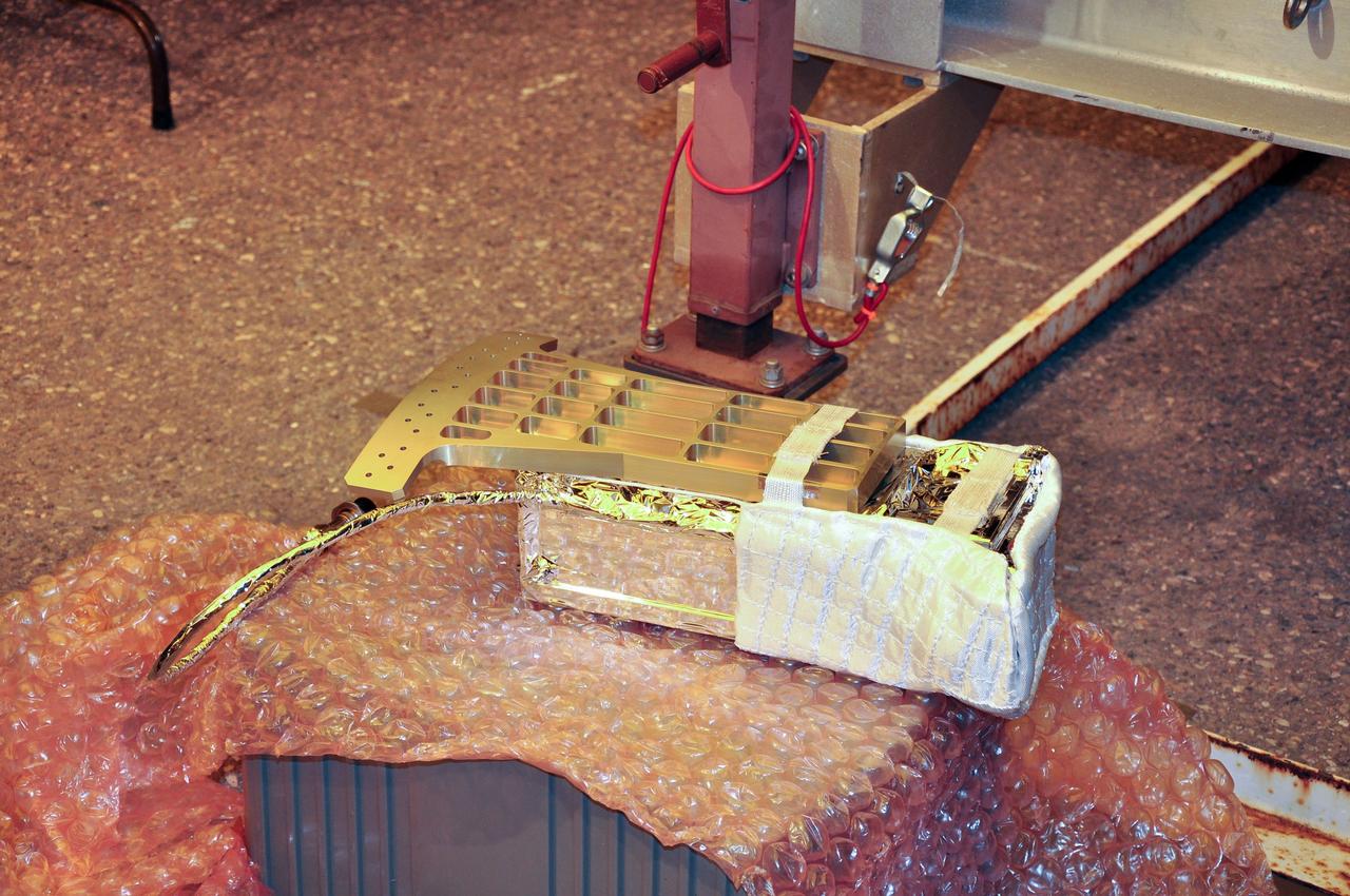 VANDENBERG AIR FORCE BASE, Calif. -- At Space Launch Complex 576-E at Vandenberg Air Force Base in California, the Poly Picosatellite Orbital Deployer, or P-POD, assembly is imaged wrapped in its thermal insulation blanket and sheeting and the attached Anodized gold aluminum bracket interface. The bracket is the connection point between the P-POD and the aft end of the Taurus rocket's third stage. The P-POD holds three CubeSats or tiny satellites, designed and created by university and college students that will be carried on the Taurus rocket along with the Glory spacecraft.        The Orbital Sciences Corp. Taurus XL rocket will carry Glory into low Earth orbit. Once Glory reaches orbit, it will collect data on the properties of aerosols and black carbon. It also will help scientists understand how the sun's irradiance affects Earth's climate. Launch is scheduled for 5:09 a.m. EST Feb. 23. For information, visit www.nasa.gov/glory. Photo credit: NASA/Randy Beaudoin, VAFB