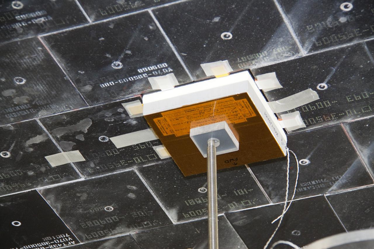 CAPE CANAVERAL, Fla. -- In Orbiter Processing Facility-1 at NASA's Kennedy Space Center in Florida, a thermal protection system technician has secured a newly installed heat shield tile in place under space shuttle Atlantis with a pressure fitting to ensure a tight bond. The tiles are part of the Orbiter Thermal Protection System, thermal shields to protect against temperatures as high as 3,000 degrees Fahrenheit, which are produced during descent for landing.      Atlantis is being prepared for the STS-135 mission, which will deliver the Raffaello multi-purpose logistics module packed with supplies, logistics and spare parts to the International Space Station. STS-135 is targeted to launch June 28, and will be the last spaceflight for the Space Shuttle Program. Photo credit: NASA/Jack Pfaller