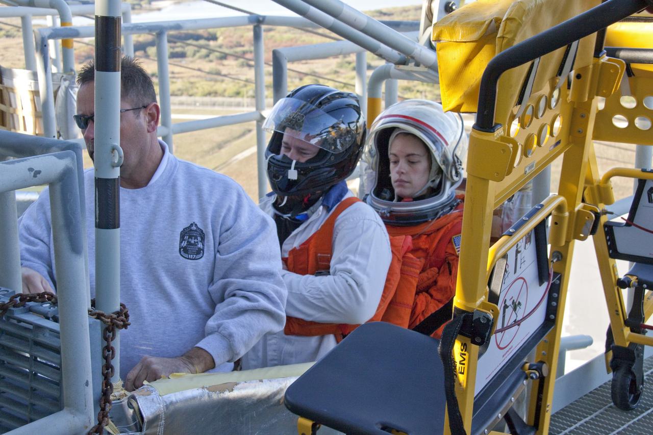 CAPE CANAVERAL, Fla. -- At NASA's Kennedy Space Center in Florida, members of an emergency escape training team perform a simulated evacuation exercise at Launch Pad 39A.           For several days, volunteers portraying astronauts, take part in training exercises which allow teams to practice emergency response procedures, including helicopter evacuation to local hospitals. Training normally involves NASA fire rescue personnel, personnel from the Air Force's 920th Rescue Wing, and medical trauma teams from central Florida hospitals, and is required every 18 months to certify Fire Rescue and Closeout Crew personnel. Photo credit: NASA/Troy Cryder