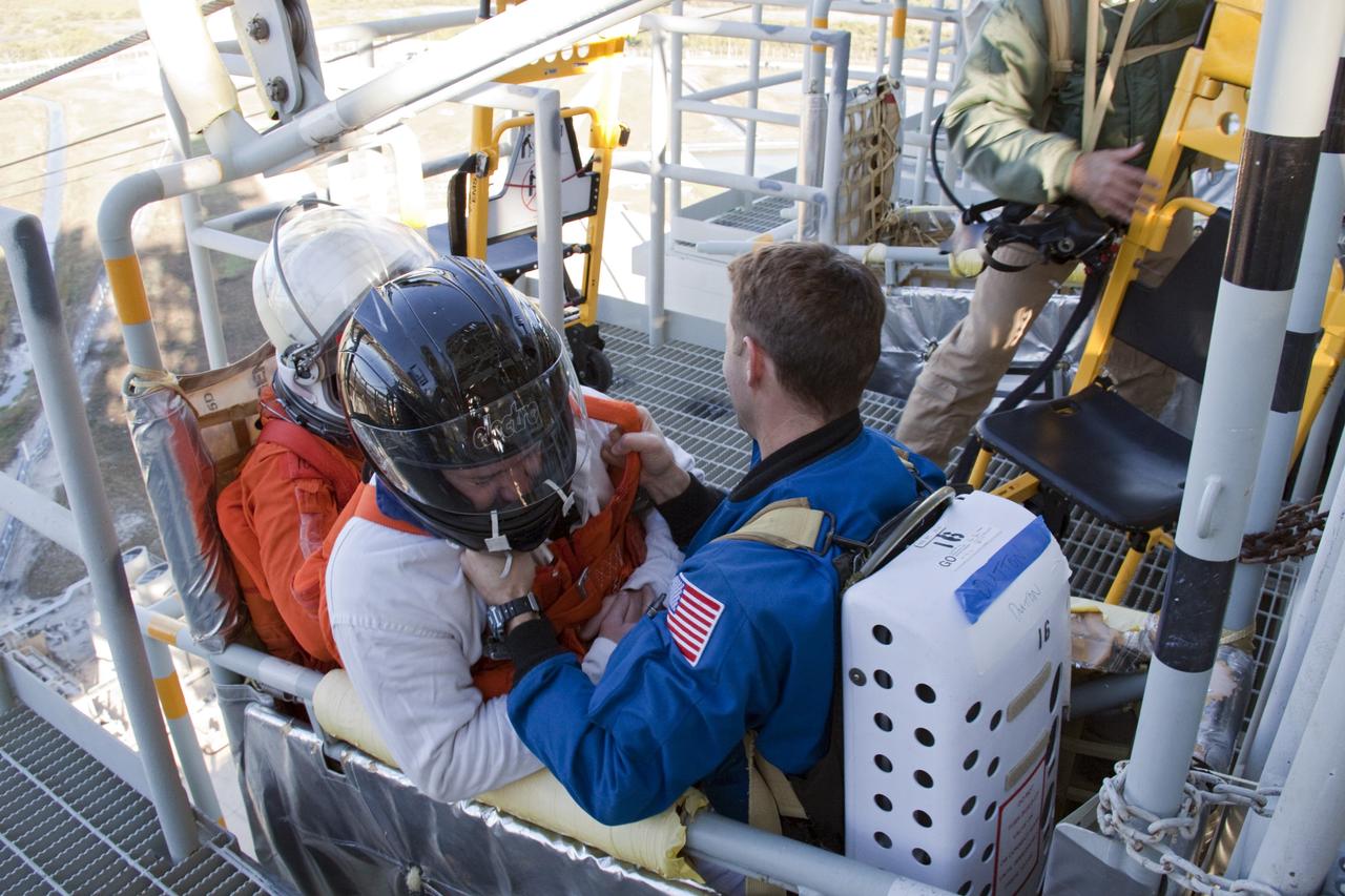 CAPE CANAVERAL, Fla. -- At NASA's Kennedy Space Center in Florida, members of an emergency escape training team perform a simulated evacuation exercise at Launch Pad 39A.           For several days, volunteers portraying astronauts, take part in training exercises which allow teams to practice emergency response procedures, including helicopter evacuation to local hospitals. Training normally involves NASA fire rescue personnel, personnel from the Air Force's 920th Rescue Wing, and medical trauma teams from central Florida hospitals, and is required every 18 months to certify Fire Rescue and Closeout Crew personnel. Photo credit: NASA/Troy Cryder