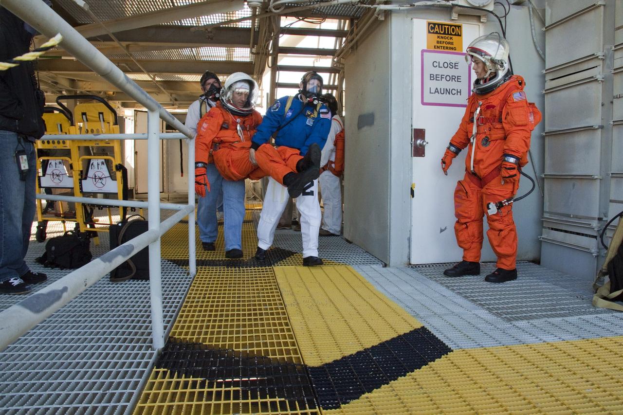 CAPE CANAVERAL, Fla. -- At NASA's Kennedy Space Center in Florida, members of an emergency escape training team perform a simulated evacuation exercise at Launch Pad 39A.           For several days, volunteers portraying astronauts, take part in training exercises which allow teams to practice emergency response procedures, including helicopter evacuation to local hospitals. Training normally involves NASA fire rescue personnel, personnel from the Air Force's 920th Rescue Wing, and medical trauma teams from central Florida hospitals, and is required every 18 months to certify Fire Rescue and Closeout Crew personnel. Photo credit: NASA/Troy Cryder