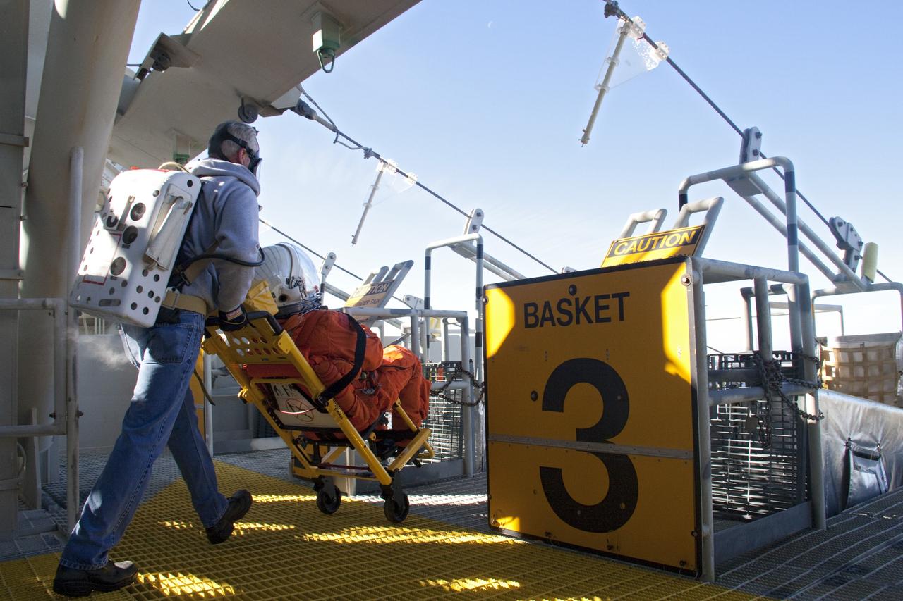 CAPE CANAVERAL, Fla. -- At NASA's Kennedy Space Center in Florida, members of an emergency escape training team perform a simulated evacuation exercise at Launch Pad 39A.        For several days, volunteers portraying astronauts, take part in training exercises which allow teams to practice emergency response procedures, including helicopter evacuation to local hospitals. Training normally involves NASA fire rescue personnel, personnel from the Air Force's 920th Rescue Wing, and medical trauma teams from central Florida hospitals, and is required every 18 months to certify Fire Rescue and Closeout Crew personnel. Photo credit: NASA/Troy Cryder