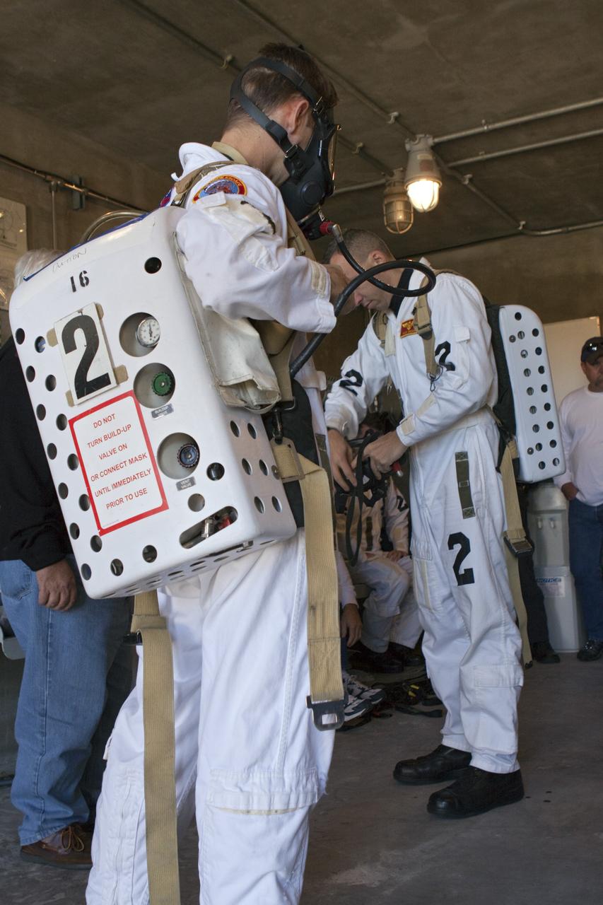CAPE CANAVERAL, Fla. -- At NASA's Kennedy Space Center in Florida, members of an emergency escape training team suit up in the bunkers below Launch Pad 39A prior to the start of a simulated evacuation exercise.       For several days, volunteers portraying astronauts, take part in training exercises which allow teams to practice emergency response procedures, including helicopter evacuation to local hospitals. Training normally involves NASA fire rescue personnel, personnel from the Air Force's 920th Rescue Wing, and medical trauma teams from central Florida hospitals, and is required every 18 months to certify Fire Rescue and Closeout Crew personnel. Photo credit: NASA/Troy Cryder