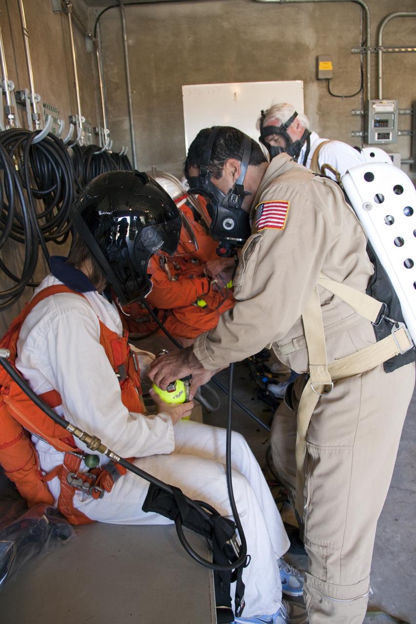CAPE CANAVERAL, Fla. -- On Launch Pad 39A at NASA's Kennedy Space Center in Florida, members of an emergency escape training team perform a simulated evacuation exercise in the bunkers behind the slidewire basket landing site.        For several days, volunteers portraying astronauts, take part in training exercises which allow teams to practice emergency response procedures, including helicopter evacuation to local hospitals. Training normally involves NASA fire rescue personnel, personnel from the Air Force's 920th Rescue Wing, and medical trauma teams from central Florida hospitals, and is required every 18 months to certify Fire Rescue and Closeout Crew personnel. Photo credit: NASA/Troy Cryder