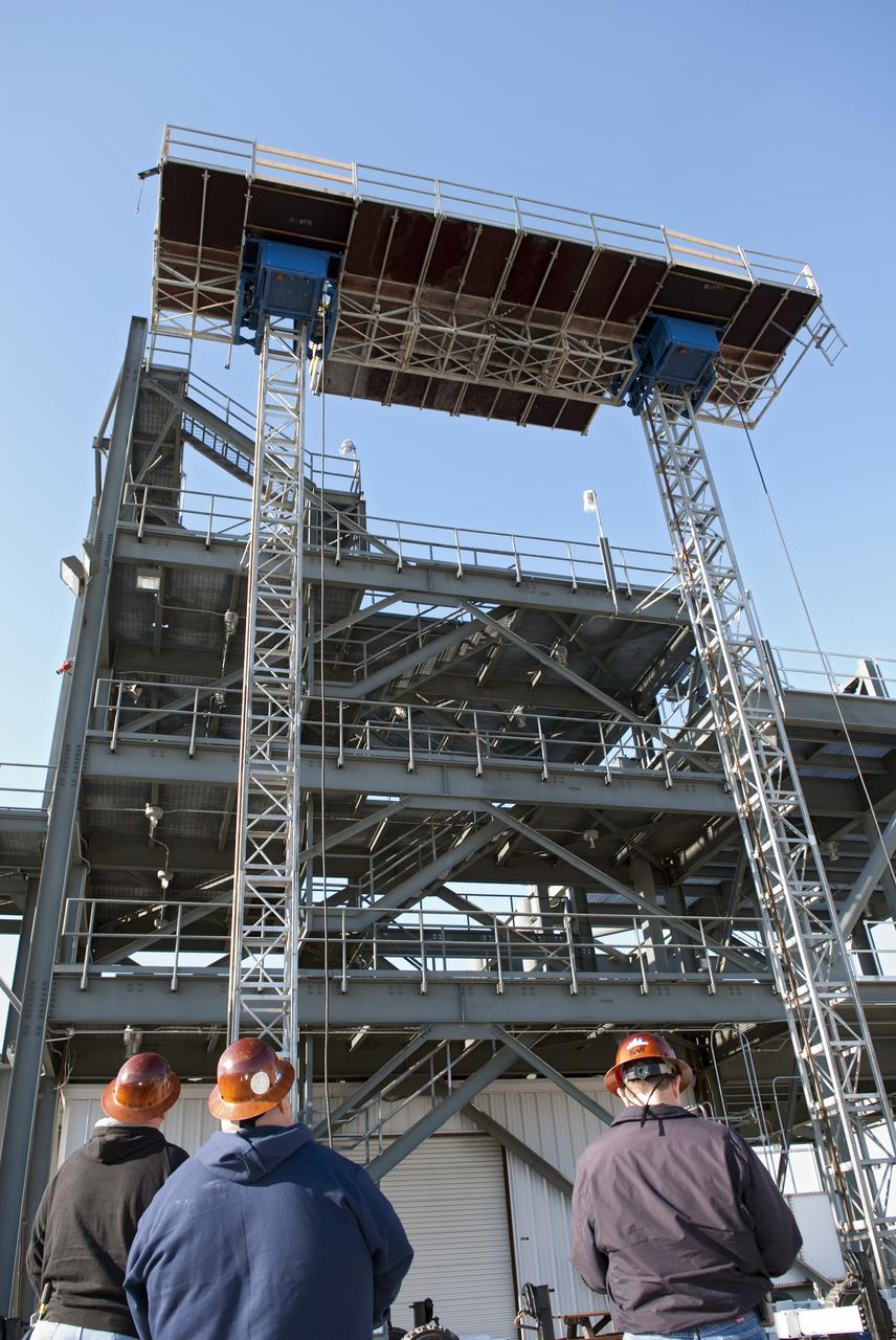 CAPE CANAVERAL, Fla. -- At NASA's Kennedy Space Center in Florida, workers receive training on a mast climber that is attached to launch simulation towers outside the Launch Equipment Test Facility. The training includes attaching carrier plates, water and air systems, and electricity to the climber to simulate working in Kennedy's Vehicle Assembly Building (VAB). Mast climbers can be substituted for fixed service structures currently inside the VAB to provide access to any type of launch vehicle.          Since 1977, the facility has supported NASA’s Launch Services, shuttle, International Space Station, and Constellation programs, as well as commercial providers. Last year, the facility underwent a major upgrade to support even more programs, projects and customers. It houses a 6,000-square-foot high bay, cable fabrication and molding shop, pneumatics shop, machine and weld shop and full-scale control room. Outside, the facility features a water flow test loop, vehicle motion simulator and a cryogenic system. Photo credit: NASA/Jim Grossmann