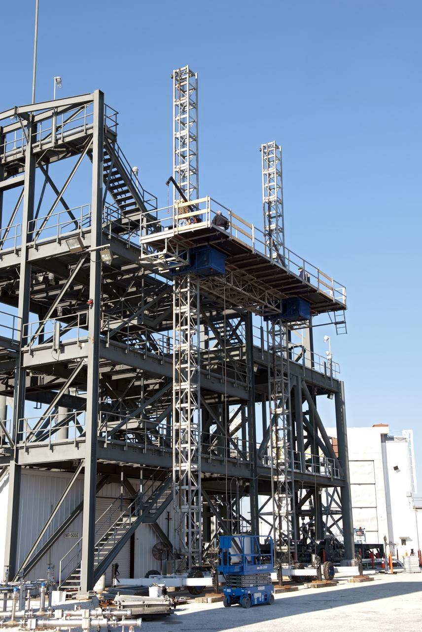 CAPE CANAVERAL, Fla. -- At NASA's Kennedy Space Center in Florida, workers receive training atop a mast climber that is attached to launch simulation towers outside the Launch Equipment Test Facility. The training includes attaching carrier plates, water and air systems, and electricity to the climber to simulate working in Kennedy's Vehicle Assembly Building (VAB). Mast climbers can be substituted for fixed service structures currently inside the VAB to provide access to any type of launch vehicle.        Since 1977, the facility has supported NASA’s Launch Services, shuttle, International Space Station, and Constellation programs, as well as commercial providers. Last year, the facility underwent a major upgrade to support even more programs, projects and customers. It houses a 6,000-square-foot high bay, cable fabrication and molding shop, pneumatics shop, machine and weld shop and full-scale control room. Outside, the facility features a water flow test loop, vehicle motion simulator and a cryogenic system. Photo credit: NASA/Jim Grossmann