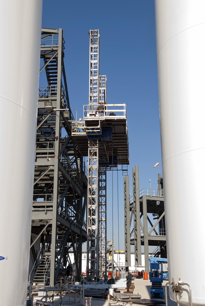 CAPE CANAVERAL, Fla. -- At NASA's Kennedy Space Center in Florida, workers receive training atop a mast climber that is attached to launch simulation towers outside the Launch Equipment Test Facility. The training includes attaching carrier plates, water and air systems, and electricity to the climber to simulate working in Kennedy's Vehicle Assembly Building (VAB). Mast climbers can be substituted for fixed service structures currently inside the VAB to provide access to any type of launch vehicle.      Since 1977, the facility has supported NASA’s Launch Services, shuttle, International Space Station, and Constellation programs, as well as commercial providers. Last year, the facility underwent a major upgrade to support even more programs, projects and customers. It houses a 6,000-square-foot high bay, cable fabrication and molding shop, pneumatics shop, machine and weld shop and full-scale control room. Outside, the facility features a water flow test loop, vehicle motion simulator and a cryogenic system. Photo credit: NASA/Jim Grossmann