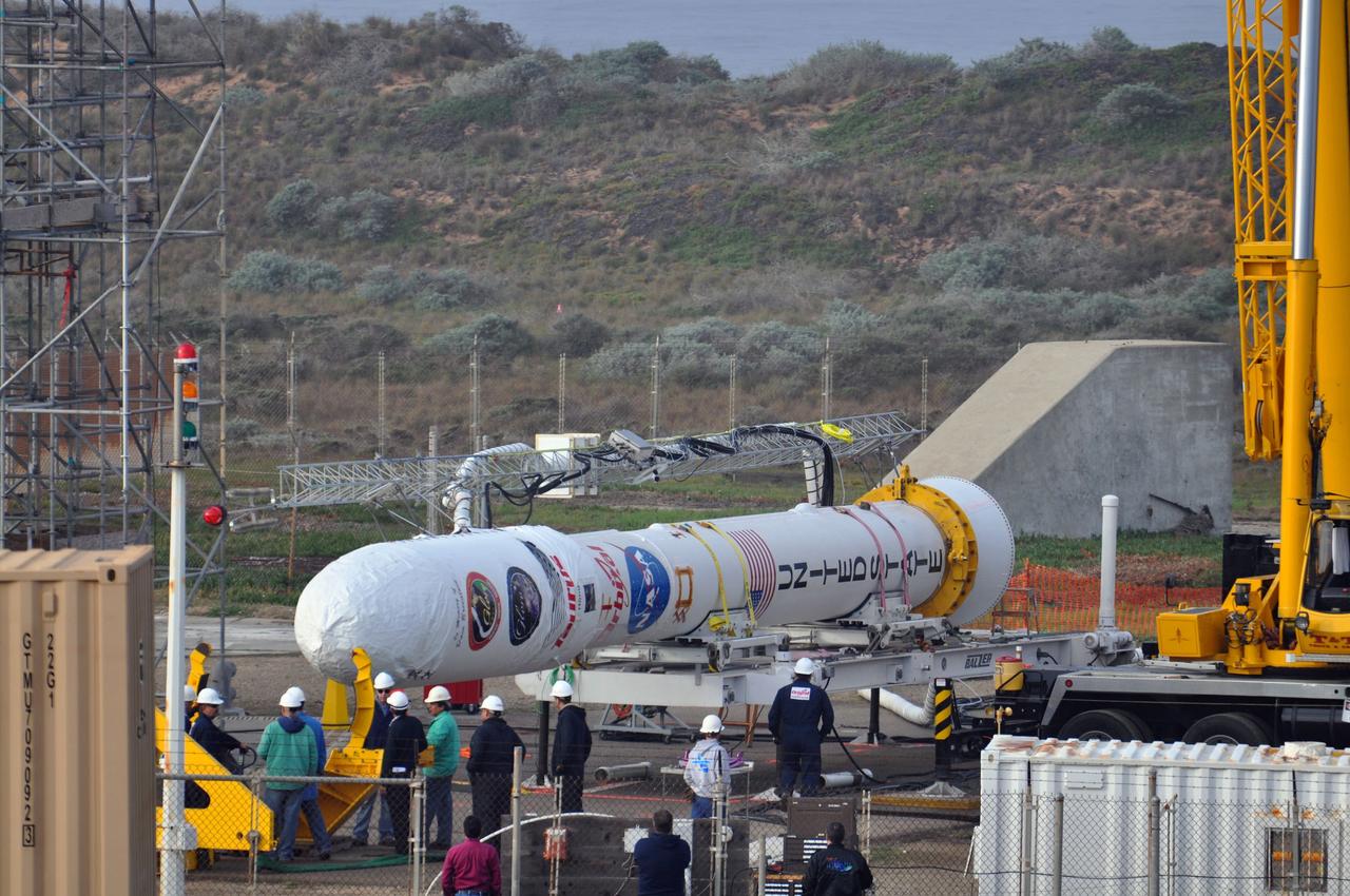 VANDENBERG AIR FORCE BASE, Calif. -- On Space Launch Complex 576-E at Vandenberg Air Force Base in California, Orbital Sciences workers prepare NASA's Glory upper stack for attachment to the Taurus XL rocket's Stage 0. The upper stack consists of Stages 1, 2 and 3 of the Taurus as well as the encapsulated Glory spacecraft.  Workers put the non-flight environmental shield over the fairing prior to assembly. A portion of the umbilical tower is attached to the upper stack which falls away from the spacecraft during liftoff.            The Orbital Sciences Taurus XL rocket will launch Glory into low Earth orbit. Once Glory reaches orbit, it will collect data on the properties of aerosols and black carbon. It also will help scientists understand how the sun's irradiance affects Earth's climate. Launch is scheduled for 5:09 a.m. EST Feb. 23. For information, visit www.nasa.gov/glory. Photo credit: NASA/Randy Beaudoin, VAFB