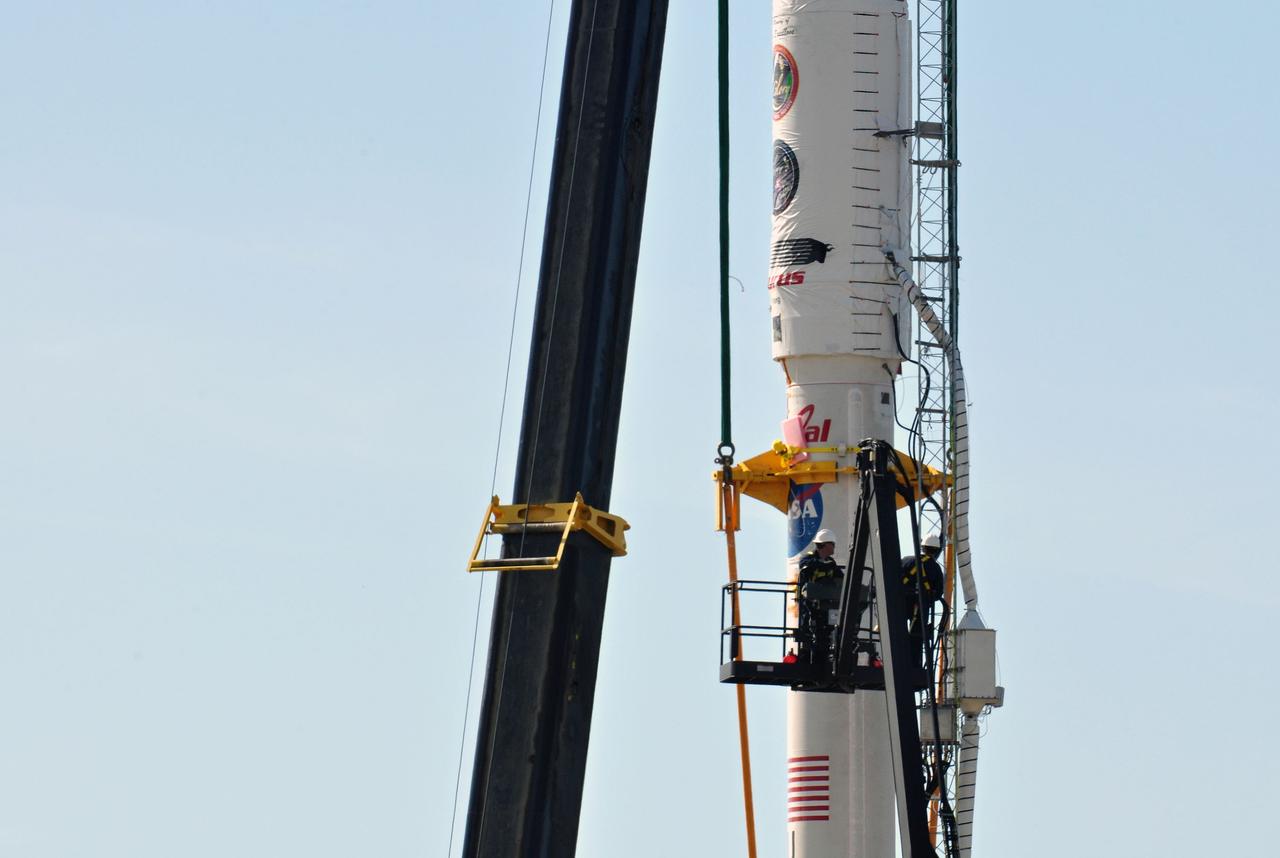 VANDENBERG AIR FORCE BASE, Calif. -- On Space Launch Complex 576-E at Vandenberg Air Force Base in California, workers in a bucket begin the process of removing the lifting fixture and sling from NASA's Glory upper stack after it was secured in place to the Taurus XL rocket's Stage 0. The upper stack consists of Stages 1, 2 and 3 of the Taurus as well as the encapsulated Glory spacecraft.         The Orbital Sciences Taurus XL rocket will launch Glory into low Earth orbit. Once Glory reaches orbit, it will collect data on the properties of aerosols and black carbon. It also will help scientists understand how the sun's irradiance affects Earth's climate. Launch is scheduled for 5:09 a.m. EST Feb. 23. For information, visit www.nasa.gov/glory. Photo credit: NASA/Randy Beaudoin, VAFB