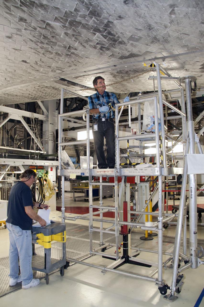 CAPE CANAVERAL, Fla. -- In Orbiter Processing Facility-1 at NASA's Kennedy Space Center in Florida, a thermal protection system technician is preparing to work on replacing some of space shuttle Atlantis' heat shield tiles.               The tiles are part of the Orbiter Thermal Protection System that protects the shuttle against temperatures as high as 3,000 degrees Fahrenheit, which are produced during descent for landing. Atlantis is being prepared for the STS-135 mission, which will carry the Raffaello multi-purpose logistics module packed with supplies, logistics and spare parts to the International Space Station. STS-135 is targeted to launch June 28, and will be the last flight for the Space Shuttle Program. Photo credit: NASA/Jack Pfaller