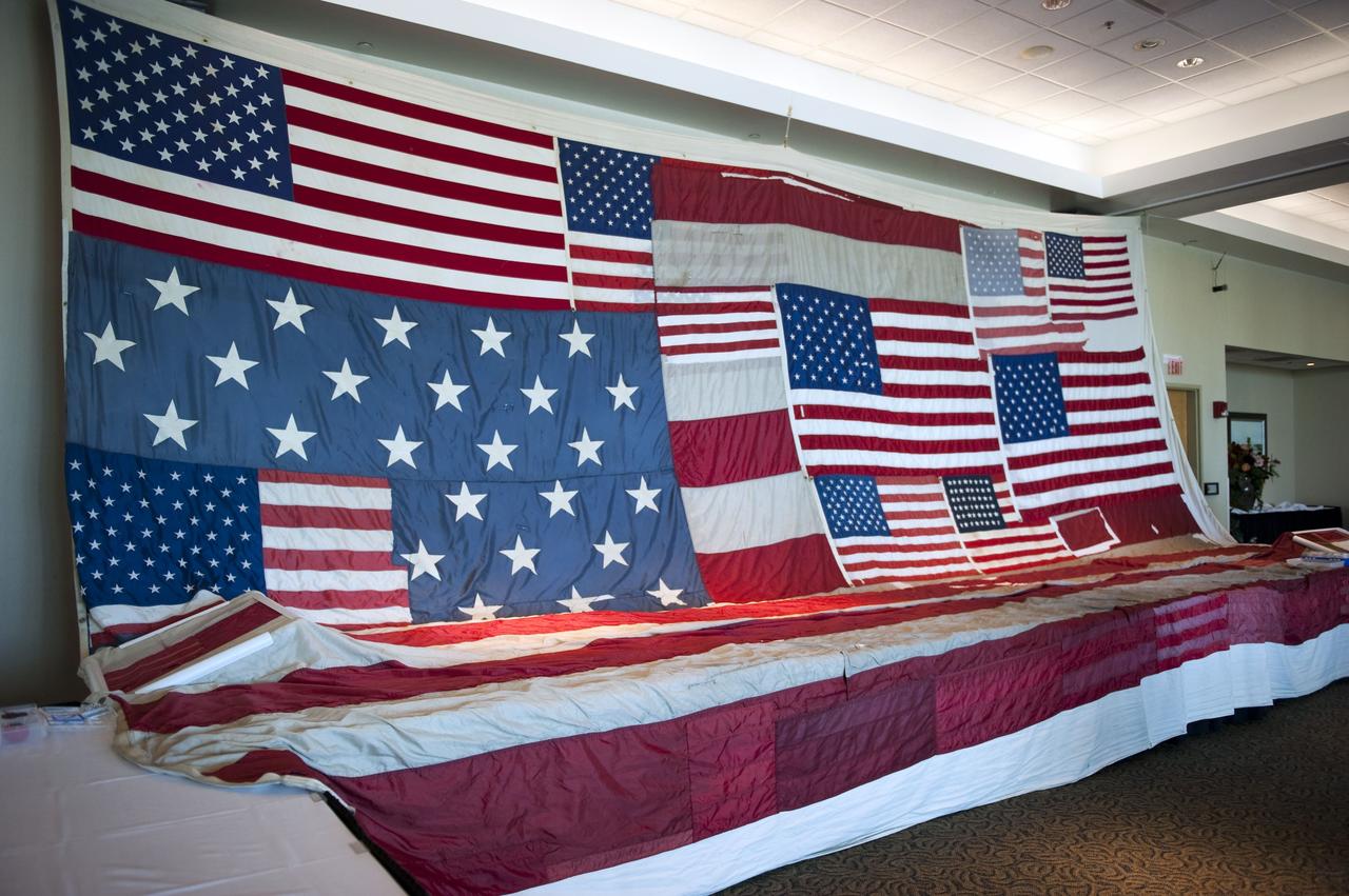 CAPE CANAVERAL, Fla. -- "The National 9/11 Flag" is on display in the Debus Conference Facility at the Kennedy Space Center Visitor Complex in Florida. The contributions of NASA, Kennedy Space Center and the state of Florida were stitched into the fabric of the American Flag, which was recovered near ground zero following the World Trade Center attacks on Sept. 11, 2001.       The "New York Says Thank You Foundation" is taking the flag on a cross-country journey to be restored to its original 13-stripe design using pieces of fabric from American flags destined for retirement in all 50 states. Once the flag is restored, it will become a permanent collection of the National September 11 Memorial Museum being built at the World Trade Center site. Photo credit: NASA/Kim Shiflett