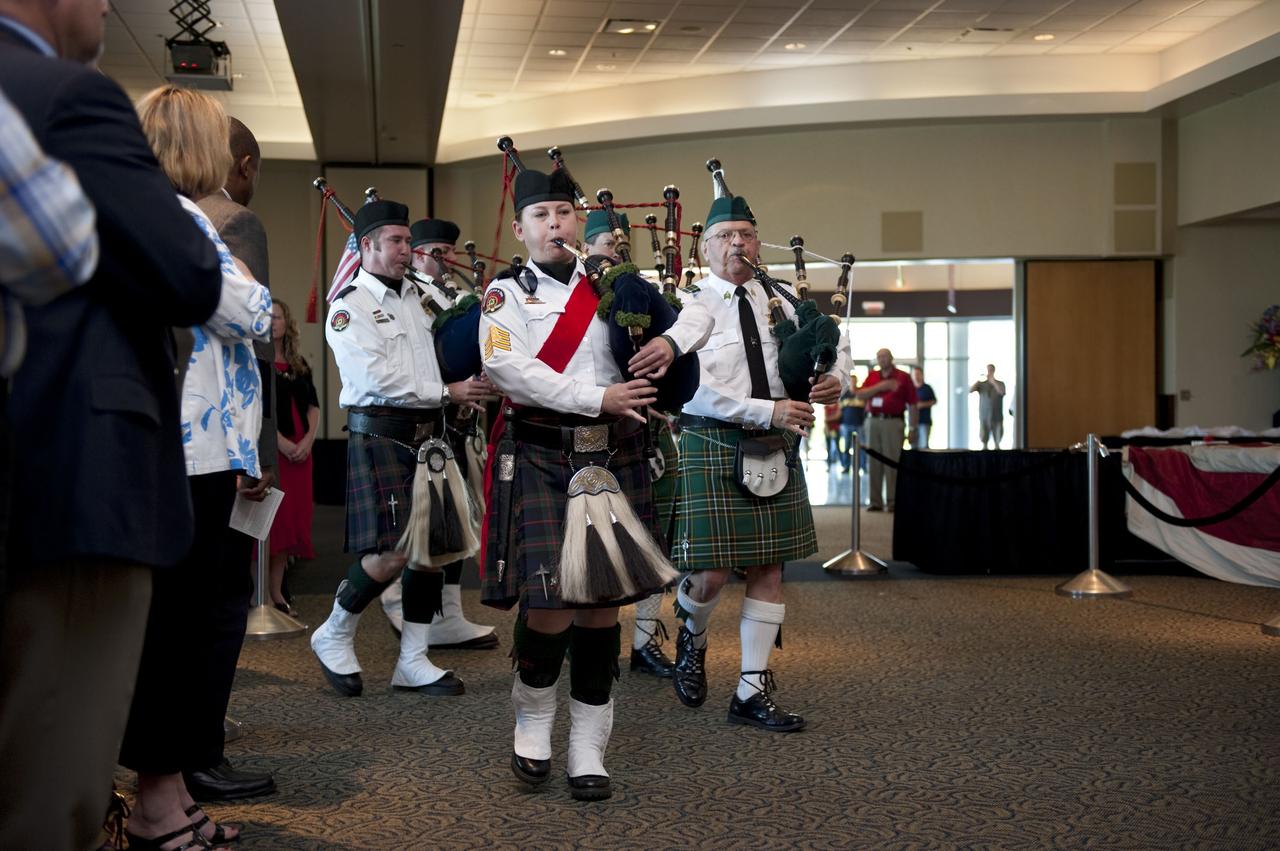 CAPE CANAVERAL, Fla. -- Members of the Brevard Police and Fire Pipes and Drums kick off the "The National 9/11 Flag" stitching ceremony in the Debus Conference Facility at the Kennedy Space Center Visitor Complex in Florida. The contributions of NASA, Kennedy Space Center and the state of Florida were stitched into the fabric of the American Flag, which was recovered near ground zero following the World Trade Center attacks on Sept. 11, 2001.     The "New York Says Thank You Foundation" is taking the flag on a cross-country journey to be restored to its original 13-stripe design using pieces of fabric from American flags destined for retirement in all 50 states. Once the flag is restored, it will become a permanent collection of the National September 11 Memorial Museum being built at the World Trade Center site. Photo credit: NASA/Kim Shiflett