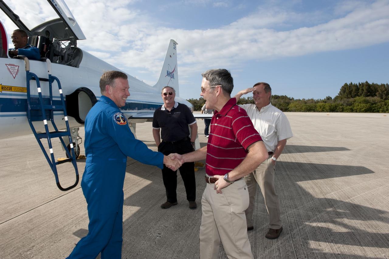 CAPE CANAVERAL, Fla. -- At NASA's Kennedy Space Center in Florida, space shuttle Discovery's STS-133 Commander Steve Lindsey greets Kennedy Center Director Bob Cabana on the Shuttle Landing Facility runway after arriving aboard a T-38 jet. Also on hand to greet the crew were Jerry Ross, chief of the Vehicle Integration Test Office, left, and Mike Leinbach, shuttle launch director. In the days leading up to their launch to the International Space Station, Lindsey and his crew members will check the fit of their launch-and-entry suits, review launch-day procedures, receive weather briefings and remain medically quarantined to prevent sickness. This will be the second launch attempt for Discovery's crew, following a scrub in November 2010 due to a hydrogen gas leak at the ground umbilical carrier plate (GUCP) as well as modifications to the external fuel tank's intertank support beams, called stringers.      Scheduled to lift off Feb. 24 at 4:50 p.m. EST, Discovery and its crew will deliver the Permanent Multipurpose Module, packed with supplies and critical spare parts, as well as Robonaut 2, the dexterous humanoid astronaut helper, to the orbiting outpost. For more information on the STS-133 mission, visit www.nasa.gov/mission_pages/shuttle/shuttlemissions/sts133/.  Photo credit: NASA/Kim Shiflett