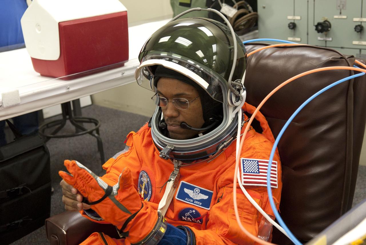 CAPE CANAVERAL, Fla. - In the Operations and Checkout Building (O&C) at NASA's Kennedy Space Center in Florida, the astronauts of space shuttle Discovery's STS-133 crew put on their launch-and-entry suits and check the fit of their helmets and gloves before heading to the Astrovan for the ride to Launch Pad 39A. Mission Specialist Michael Barratt, seen here, is making his first flight aboard a space shuttle. Barratt has called the space station home before, though, after spending 199 days as a crew member of Expeditions 19 and 20 in 2009. Scheduled to lift off Feb. 24 at 4:50 p.m. EST, Discovery and its crew will deliver the Permanent Multipurpose Module, packed with supplies and critical spare parts, as well as Robonaut 2, the dexterous humanoid astronaut helper, to the International Space Station. Discovery, which will fly its 39th mission, is scheduled to be retired following STS-133. This will be the 133rd Space Shuttle Program mission and the 35th shuttle voyage to the space station. For more information on the STS-133 mission, visit www.nasa.gov/mission_pages/shuttle/shuttlemissions/sts133/. Photo credit: NASA/Jim Grossmann