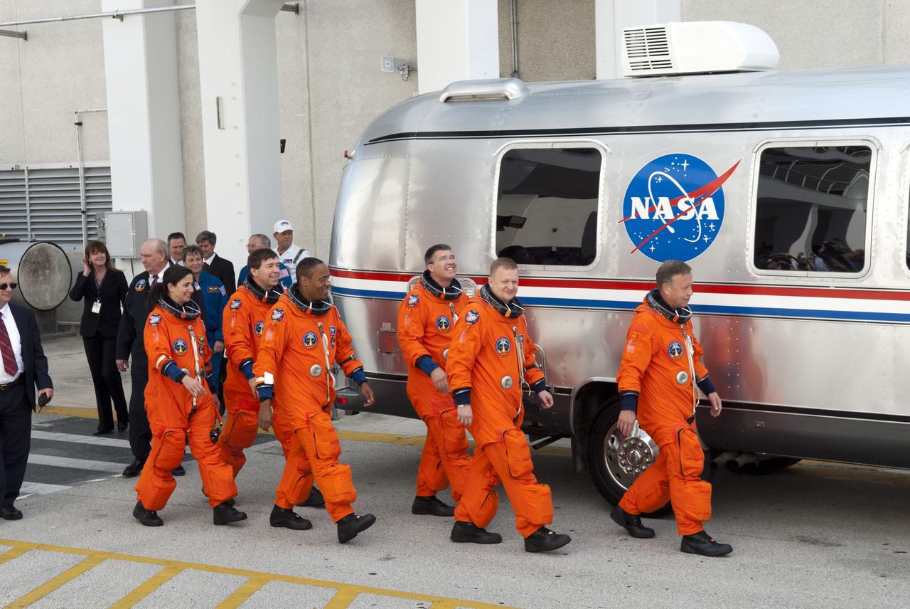 CAPE CANAVERAL, Fla. -- At the Operations and Checkout Building at NASA's Kennedy Space Center in Florida, space shuttle Discovery's STS-133 astronauts, dressed in their orange launch-and-entry suits, make their way to the Astrovan which will transport them to Launch Pad 39A. From left are Mission Specialists Nicole Stott, Michael Barratt, Alvin Drew and Steve Bowen; Pilot Eric Boe; and Commander Steve Lindsey. Discovery and its six-member crew will deliver the Permanent Multipurpose Module, packed with supplies and critical spare parts, as well as Robonaut 2, the dexterous humanoid astronaut helper, to the International Space Station. Discovery, which will fly its 39th mission, is scheduled to be retired following STS-133. This will be the 133rd Space Shuttle Program mission and the 35th shuttle voyage to the space station. For more information on the STS-133 mission, visit www.nasa.gov/mission_pages/shuttle/shuttlemissions/sts133/. Photo credit: NASA/Jim Grossmann