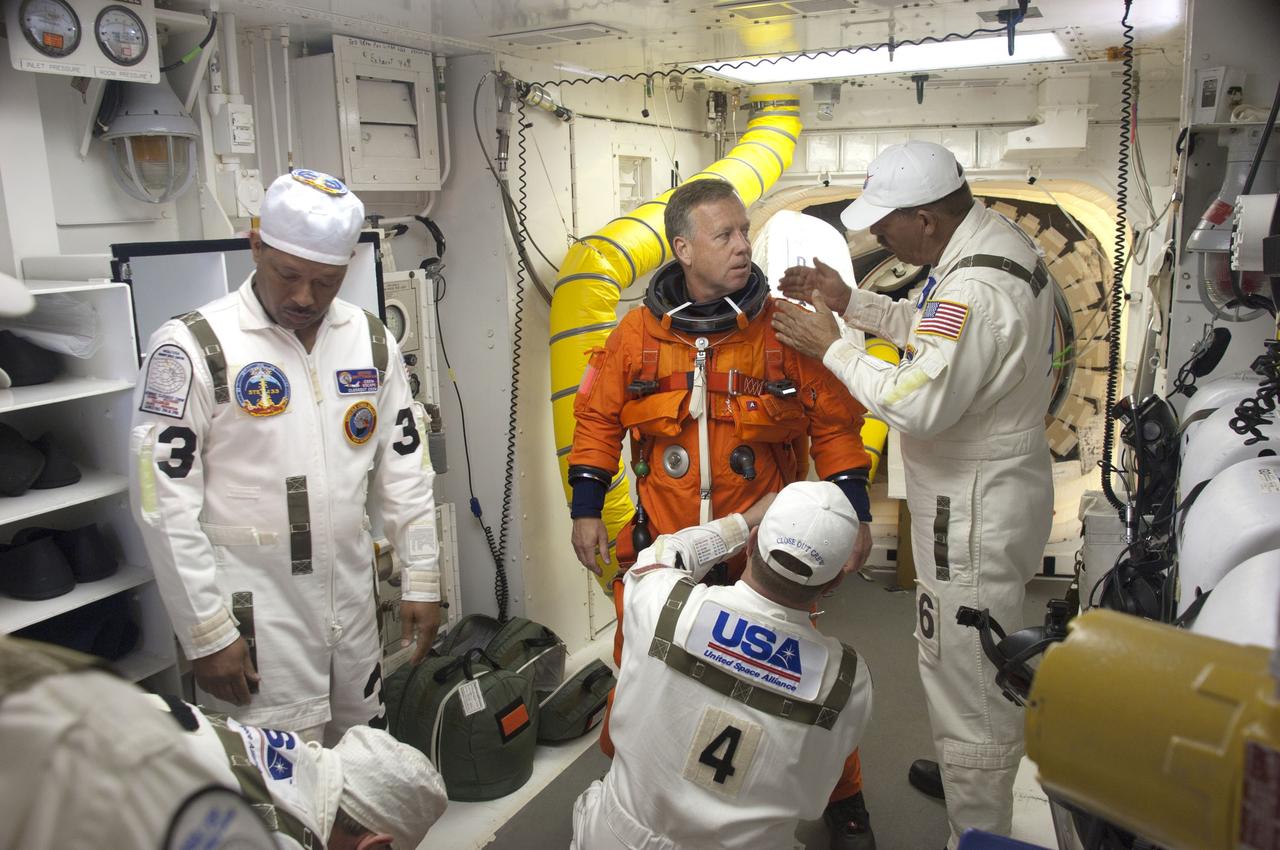 CAPE CANAVERAL, Fla. - In the White Room at Launch Pad 39A at NASA's Kennedy Space Center in Florida, United Space Alliance spacesuit technicians help STS-133 Commander Steve Lindsey put on the parachute for his launch-and-entry suit before he enters space shuttle Discovery through the crew hatch in the background. Lindsey will be making his fifth spaceflight and third aboard Discovery. Since his most recent mission -- STS-121 in 2006 -- Lindsey served as chief of the Astronaut Office at NASA's Johnson Space Center in Houston.        Scheduled to lift off Feb. 24 at 4:50 p.m. EST, Discovery and its crew will deliver the Permanent Multipurpose Module, packed with supplies and critical spare parts, as well as Robonaut 2, the dexterous humanoid astronaut helper, to the International Space Station. Discovery, which will fly its 39th mission, is scheduled to be retired following STS-133. This will be the 133rd Space Shuttle Program mission and the 35th shuttle voyage to the space station. For more information on the STS-133 mission, visit www.nasa.gov/mission_pages/shuttle/shuttlemissions/sts133/.  Photo credit: NASA/Sandra Joseph and Kevin O'Connell