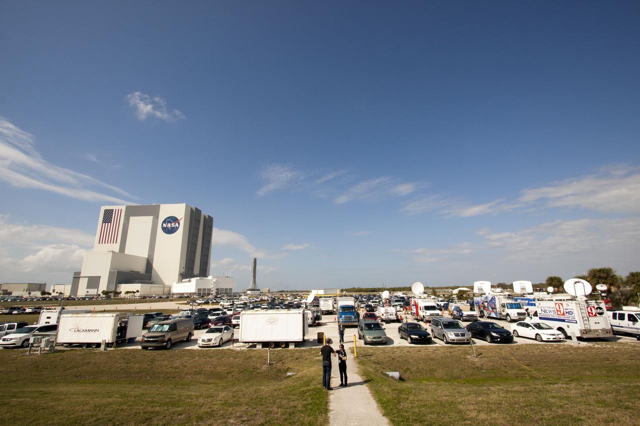 CAPE CANAVERAL, Fla. -- The enormous Vehicle Assembly Building is seen prominently in the background at NASA's Kennedy Space Center in Florida, overlooking the parking spaces below the Press Site filled with news satellite trucks and media vehicles, there to cover the final launch of space shuttle Discovery on the STS-133 mission. Discovery and its six-member crew will deliver the Permanent Multipurpose Module, packed with supplies and critical spare parts, as well as Robonaut 2 to the International Space Station. For more information on the STS-133 mission, visit www.nasa.gov/mission_pages/shuttle/shuttlemissions/sts133/. Photo Credit: NASA/Troy Cryder