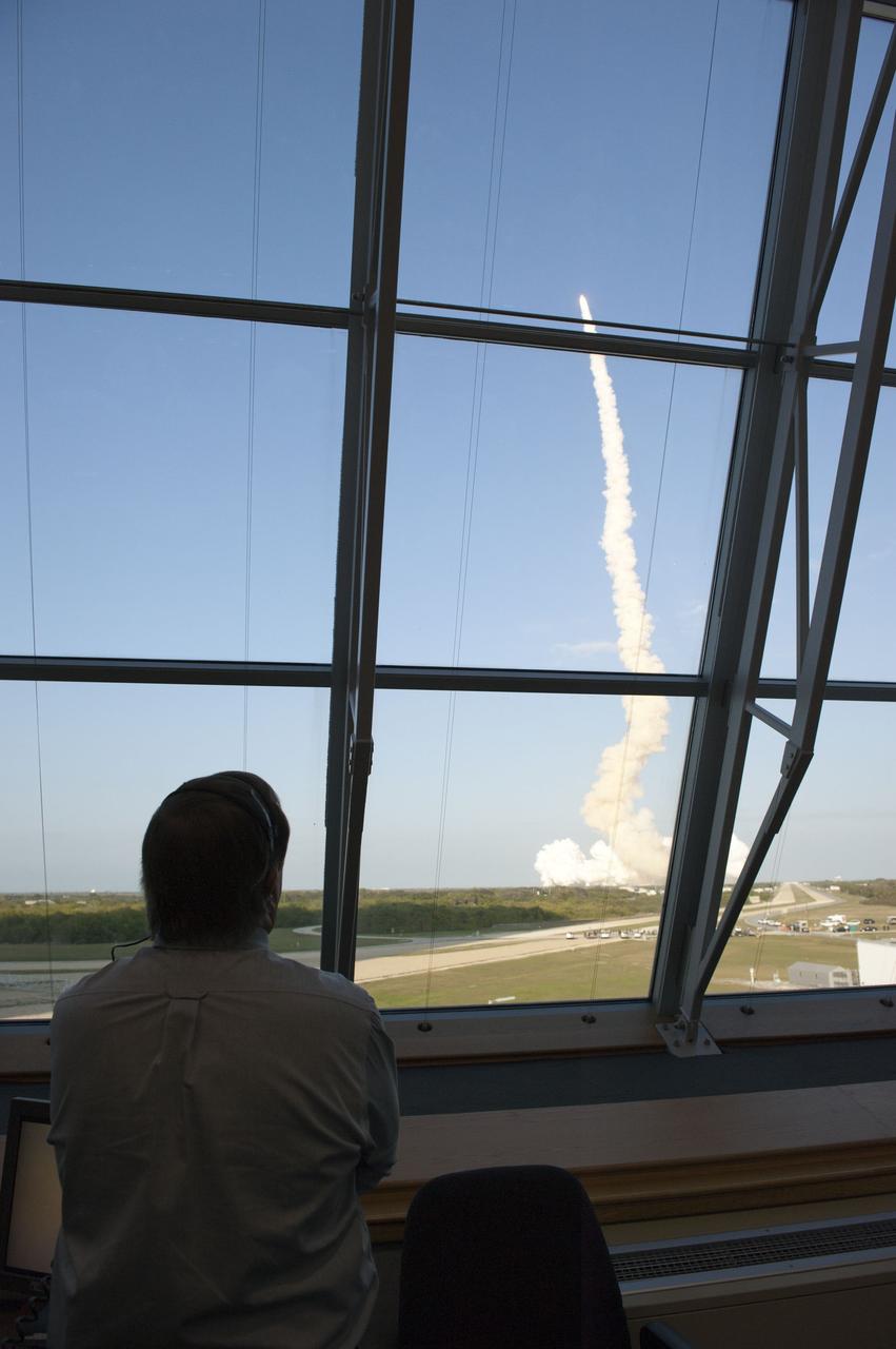 CAPE CANAVERAL, Fla. -- In Firing Room 4 of the Launch Control Center at NASA's Kennedy Space Center in Florida, Shuttle Launch Director Mike Leinbach watches  space shuttle Discovery blaze a trail of smoke and steam as it heads toward orbit on the STS-133 mission to the International Space Station.         Discovery and its six-member crew are on a mission to deliver the Permanent Multipurpose Module, packed with supplies and critical spare parts, as well as Robonaut 2, the dexterous humanoid astronaut helper, to the orbiting outpost. Discovery is making its 39th mission and is scheduled to be retired following STS-133. This is the 133rd Space Shuttle Program mission and the 35th shuttle voyage to the space station. For more information on the STS-133 mission, visit www.nasa.gov/mission_pages/shuttle/shuttlemissions/sts133/. Photo credit: NASA/Kim Shiflett