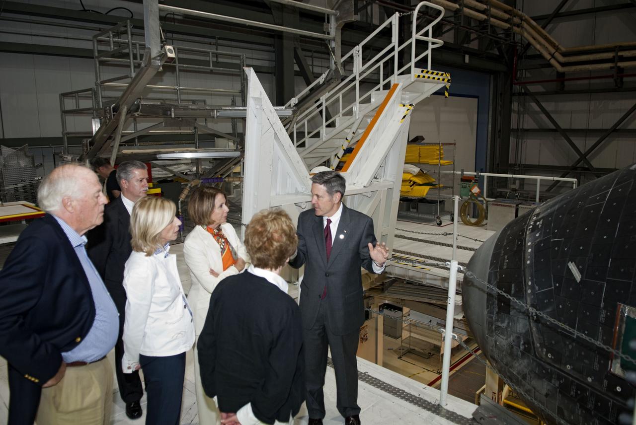 CAPE CANAVERAL, Fla. -- CAPE CANAVERAL, Fla. -- NASA Kennedy Space Center Director Robert Cabana, right, explains the operations taking place at Florida's space center to House Of Representatives Democratic Leader Nancy Pelosi, from California's 8th District, fourth from left, and other VIPs. They are at Florida's space center to witness space shuttle Discovery make history as it lifts off on its final scheduled mission from Launch Pad 39A. While at the center, they attended a presentation in the Operations Support Building II and toured Orbiter Processing Facilities 1 and 2 where shuttles Atlantis and Endeavour are being prepared for their final missions respectively.    Discovery and its six-member STS-133 crew will deliver the Permanent Multipurpose Module, packed with supplies and critical spare parts, as well as Robonaut 2, the dexterous humanoid astronaut helper, to the International Space Station. Discovery will make its 39th mission and is scheduled to be retired following STS-133. This will be the 133rd Space Shuttle Program mission and the 35th shuttle voyage to the space station. For more information on the STS-133 mission, visit www.nasa.gov/mission_pages/shuttle/shuttlemissions/sts133/.  Photo credit: NASA/Jim Grossmann