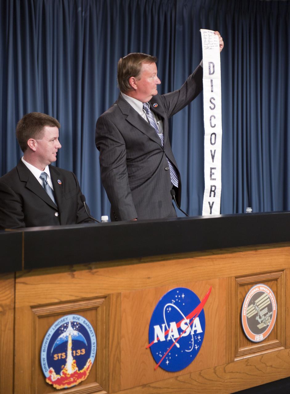 CAPE CANAVERAL, Fla. -- Space Shuttle Program Launch Integration Manager Mike Moses looks on proudly as Shuttle Launch Director Mike Leinbach holds up a Discovery banner signed by the STS-133 astronauts, at a news conference held in the Press Site auditorium at NASA's Kennedy Space Center in Florida following today's successful launch of space shuttle Discovery. Shuttle Discovery lifted off at 4:53 p.m. EST. The six-member crew will deliver the Permanent Multipurpose Module, packed with supplies and critical spare parts, as well as Robonaut 2, the dexterous humanoid astronaut helper, to the orbiting outpost. Discovery is flying on its 39th and final mission and is scheduled to be retired following STS-133. This is the 133rd Space Shuttle Program mission and the 35th shuttle voyage to the space station. For more information on the STS-133 mission, visit www.nasa.gov/mission_pages/shuttle/shuttlemissions/sts133/. Photo credit: NASA/Kim Shiflett