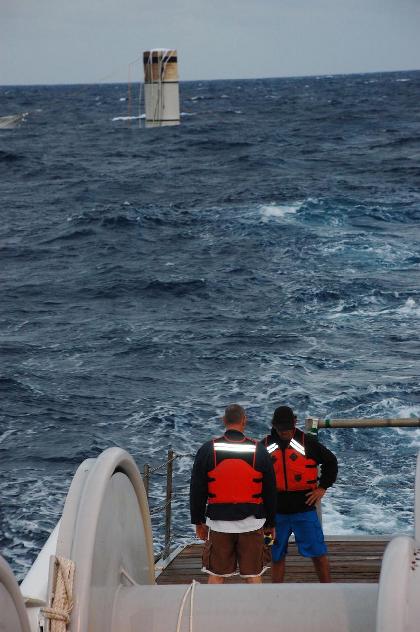 CAPE CANAVERAL, Fla. -- Part of a spent booster is seen in the background bobbing in the Atlantic Ocean as deck hands on Freedom Star, one of NASA's solid rocket booster retrieval vessel prepare to recover it after space shuttle Discovery's STS-133 launch.            The shuttle’s two solid rocket booster casings and associated flight hardware are recovered in the Atlantic Ocean after every launch by Liberty Star and Freedom Star. The boosters impact the Atlantic about seven minutes after liftoff and the retrieval ships are stationed about 10 miles from the impact area at the time of splashdown. After the spent segments are processed, they will be transported to Utah, where they will be refurbished and stored, if needed. Photo credit: NASA/Ben Smegelsky