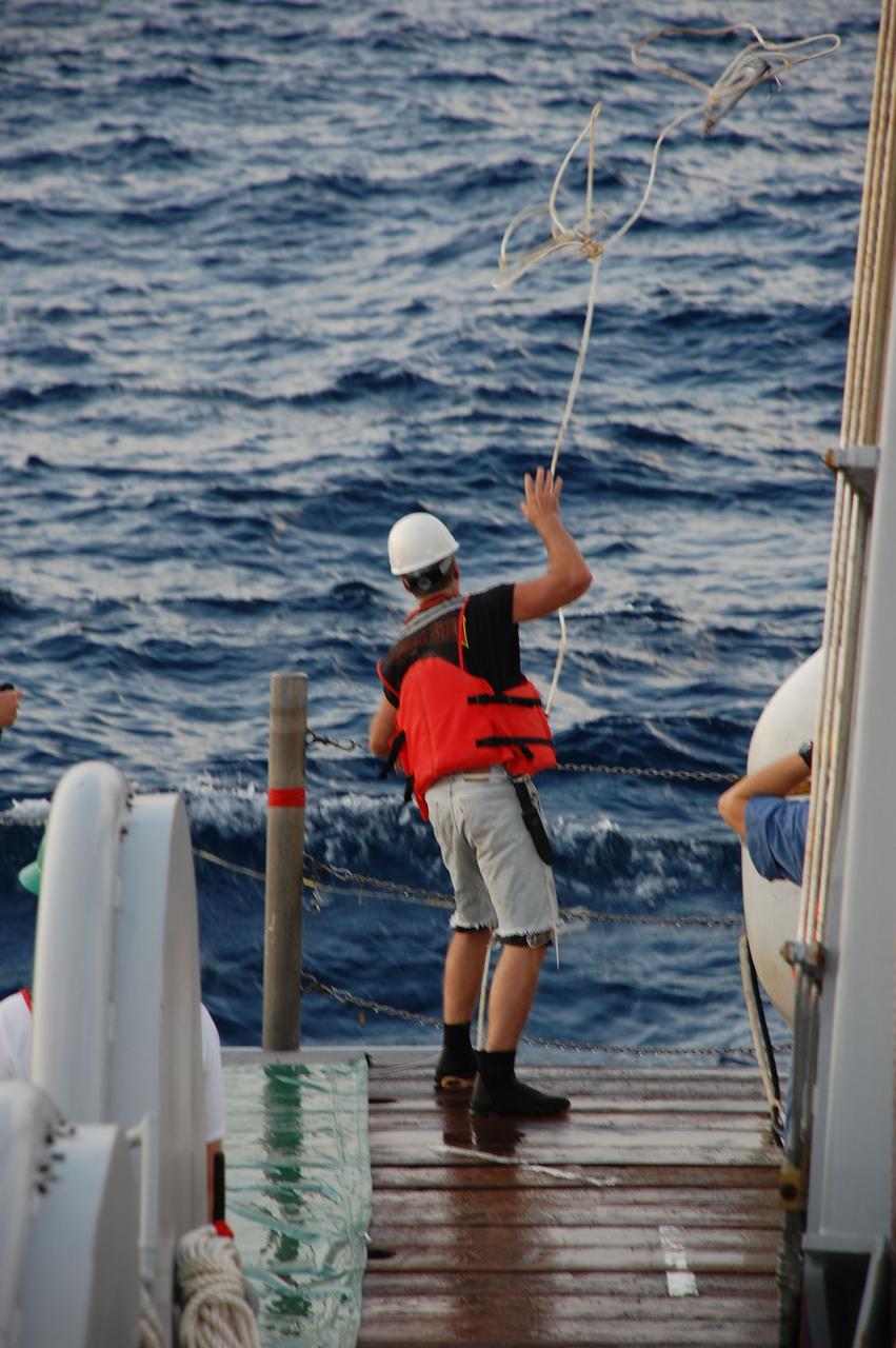 CAPE CANAVERAL, Fla. -- A crew member from Freedom Star, one of NASA's solid rocket booster retrieval ships, throws a tow line into the Atlantic Ocean in order to capture the left spent booster nose cap after space shuttle Discovery's STS-133 launch.          The shuttle’s two solid rocket booster casings and associated flight hardware are recovered in the Atlantic Ocean after every launch by Liberty Star and Freedom Star. The boosters impact the Atlantic about seven minutes after liftoff and the retrieval ships are stationed about 10 miles from the impact area at the time of splashdown. After the spent segments are processed, they will be transported to Utah, where they will be refurbished and stored, if needed. Photo credit: NASA/Ben Smegelsky