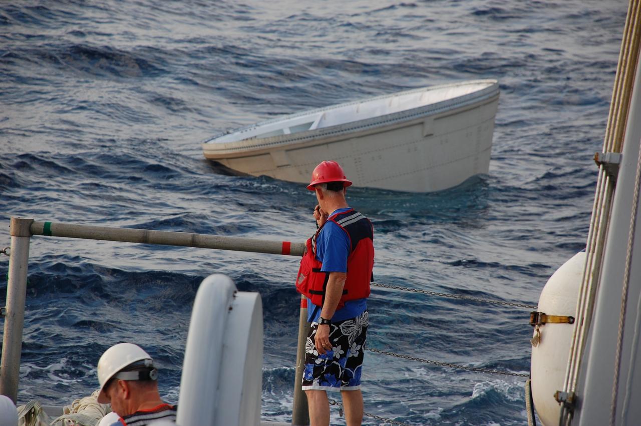 CAPE CANAVERAL, Fla. -- Crew members from Freedom Star, one of NASA's solid rocket booster retrieval ships, prepare to recover the left spent booster nose cap from the Atlantic Ocean after space shuttle Discovery's STS-133 launch.          The shuttle’s two solid rocket booster casings and associated flight hardware are recovered in the Atlantic Ocean after every launch by Liberty Star and Freedom Star. The boosters impact the Atlantic about seven minutes after liftoff and the retrieval ships are stationed about 10 miles from the impact area at the time of splashdown. After the spent segments are processed, they will be transported to Utah, where they will be refurbished and stored, if needed. Photo credit: NASA/Ben Smegelsky