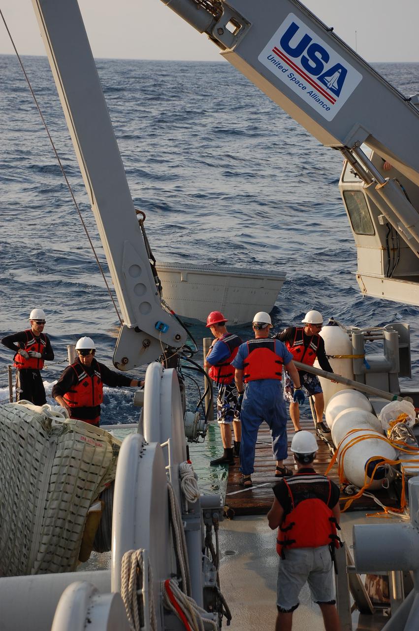 CAPE CANAVERAL, Fla. -- Crew members from Freedom Star, one of NASA's solid rocket booster retrieval ships, recover the left spent booster nose cap from the Atlantic Ocean after space shuttle Discovery's STS-133 launch. The shuttle’s two solid rocket booster casings and associated flight hardware are recovered in the Atlantic Ocean after every launch by Liberty Star and Freedom Star. The boosters impact the Atlantic about seven minutes after liftoff and the retrieval ships are stationed about 10 miles from the impact area at the time of splashdown. After the spent segments are processed, they will be transported to Utah, where they will be refurbished and stored, if needed. Photo credit: NASA/Ben Smegelsky