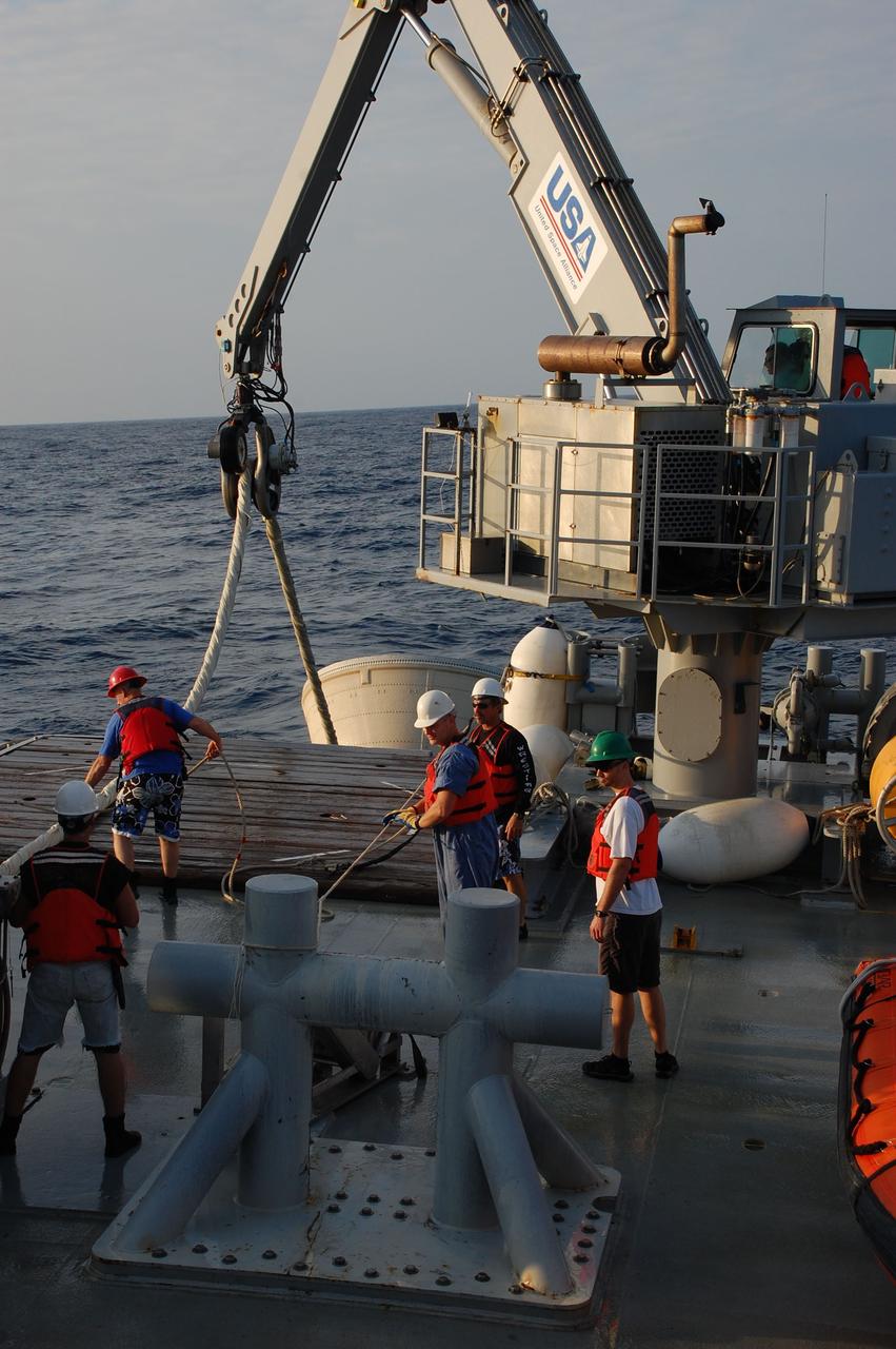 CAPE CANAVERAL, Fla. -- Crew members from Freedom Star, one of NASA's solid rocket booster retrieval ships, use a crane to pull the left spent booster nose cap out of the Atlantic Ocean after space shuttle Discovery's STS-133 launch.          The shuttle’s two solid rocket booster casings and associated flight hardware are recovered in the Atlantic Ocean after every launch by Liberty Star and Freedom Star. The boosters impact the Atlantic about seven minutes after liftoff and the retrieval ships are stationed about 10 miles from the impact area at the time of splashdown. After the spent segments are processed, they will be transported to Utah, where they will be refurbished and stored, if needed. Photo credit: NASA/Ben Smegelsky