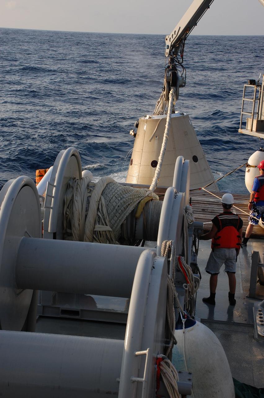 CAPE CANAVERAL, Fla. -- Crew members from Freedom Star, one of NASA's solid rocket booster retrieval ships, use a crane to pull the left spent booster nose cap out of the Atlantic Ocean after space shuttle Discovery's STS-133 launch.          The shuttle’s two solid rocket booster casings and associated flight hardware are recovered in the Atlantic Ocean after every launch by Liberty Star and Freedom Star. The boosters impact the Atlantic about seven minutes after liftoff and the retrieval ships are stationed about 10 miles from the impact area at the time of splashdown. After the spent segments are processed, they will be transported to Utah, where they will be refurbished and stored, if needed. Photo credit: NASA/Ben Smegelsky