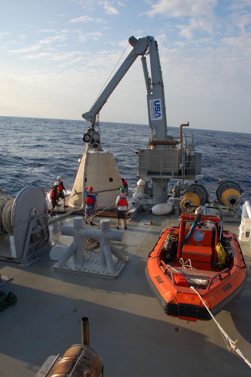 CAPE CANAVERAL, Fla. -- Crew members on Freedom Star, one of NASA's solid rocket booster retrieval ships, use a crane to pull the left spent booster nose cap out of the Atlantic Ocean after space shuttle Discovery's STS-133 launch.      The shuttle’s two solid rocket booster casings and associated flight hardware are recovered in the Atlantic Ocean after every launch by Liberty Star and Freedom Star. The boosters impact the Atlantic about seven minutes after liftoff and the retrieval ships are stationed about 10 miles from the impact area at the time of splashdown. After the spent segments are processed, they will be transported to Utah, where they will be refurbished and stored, if needed. Photo credit: NASA/Ben Smegelsky