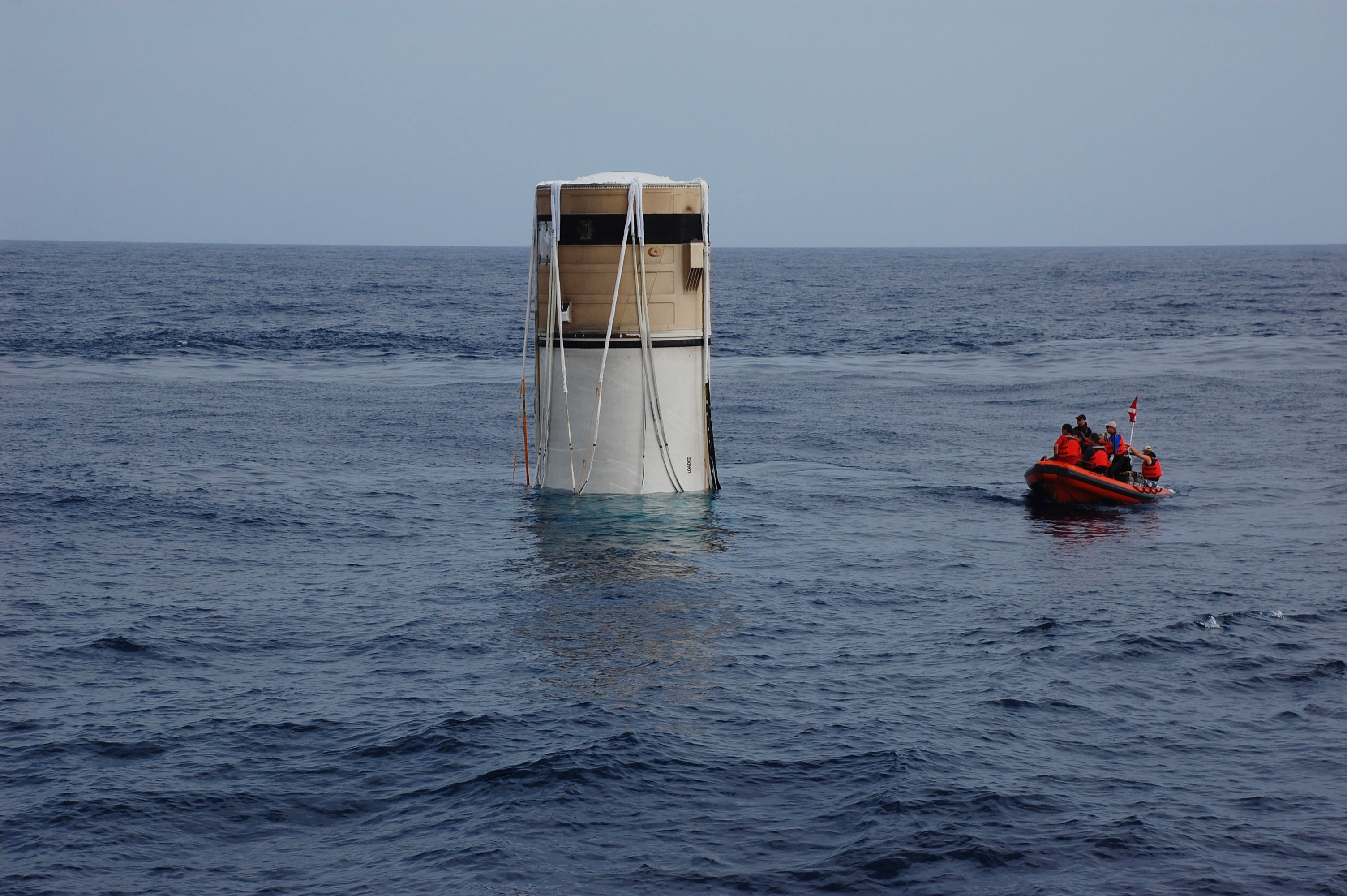 CAPE CANAVERAL, Fla. -- Crew members from Freedom Star, one of NASA's solid rocket booster retrieval ships, use a skiff to approach the left spent booster bobbing in the Atlantic Ocean after space shuttle Discovery's STS-133 launch.        The shuttle’s two solid rocket booster casings and associated flight hardware are recovered in the Atlantic Ocean after every launch by Liberty Star and Freedom Star. The boosters impact the Atlantic about seven minutes after liftoff and the retrieval ships are stationed about 10 miles from the impact area at the time of splashdown. After the spent segments are processed, they will be transported to Utah, where they will be refurbished and stored, if needed. Photo credit: NASA/Ben Smegelsky