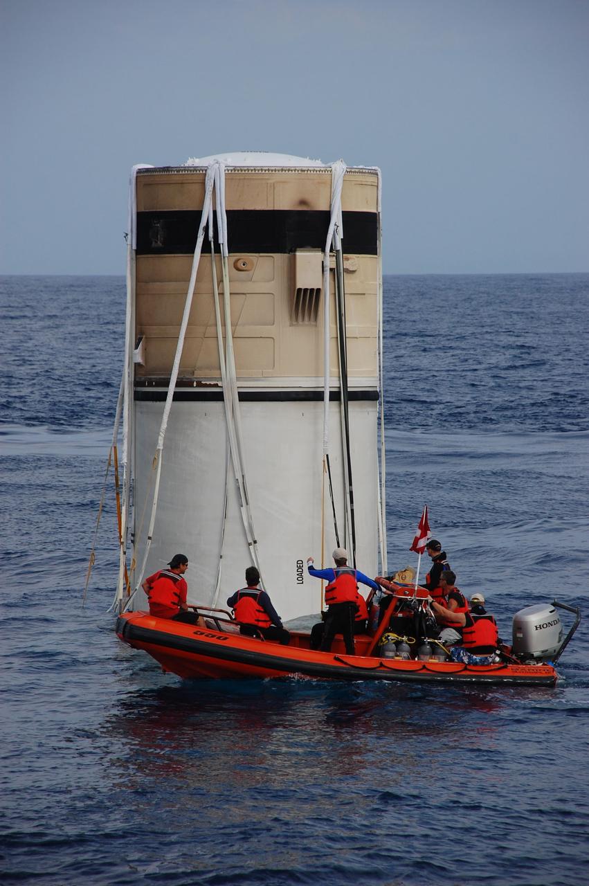 CAPE CANAVERAL, Fla. -- Crew members from Freedom Star, one of NASA's solid rocket booster retrieval ships, use a skiff to approach the left spent booster bobbing in the Atlantic Ocean after space shuttle Discovery's STS-133 launch.        The shuttle’s two solid rocket booster casings and associated flight hardware are recovered in the Atlantic Ocean after every launch by Liberty Star and Freedom Star. The boosters impact the Atlantic about seven minutes after liftoff and the retrieval ships are stationed about 10 miles from the impact area at the time of splashdown. After the spent segments are processed, they will be transported to Utah, where they will be refurbished and stored, if needed. Photo credit: NASA/Ben Smegelsky