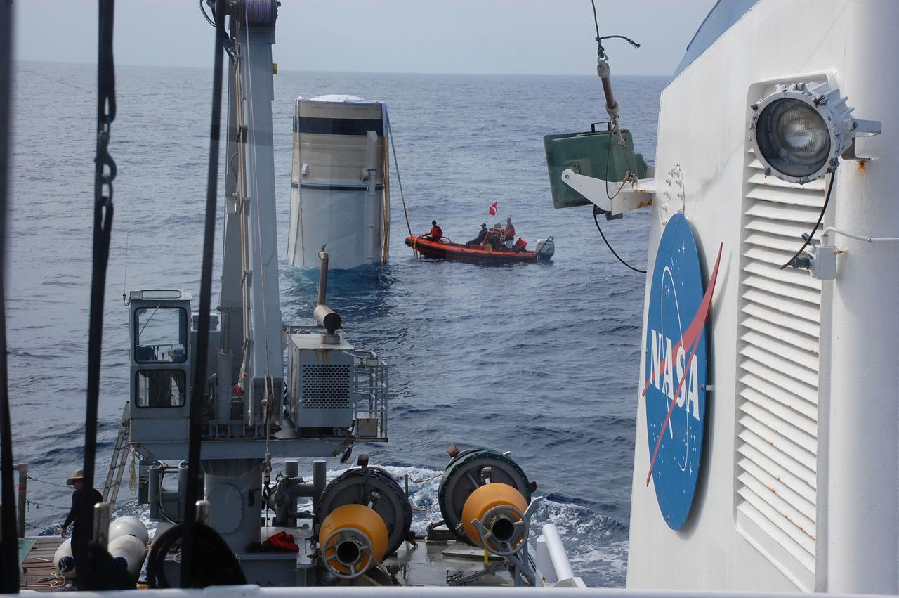 CAPE CANAVERAL, Fla. -- Crew members in a skiff from Freedom Star, one of NASA's solid rocket booster retrieval ships, approach and inspect the left spent booster bobbing in the Atlantic Ocean after space shuttle Discovery's STS-133 launch.            The shuttle’s two solid rocket booster casings and associated flight hardware are recovered in the Atlantic Ocean after every launch by Liberty Star and Freedom Star. The boosters impact the Atlantic about seven minutes after liftoff and the retrieval ships are stationed about 10 miles from the impact area at the time of splashdown. After the spent segments are processed, they will be transported to Utah, where they will be refurbished and stored, if needed. Photo credit: NASA/Ben Smegelsky